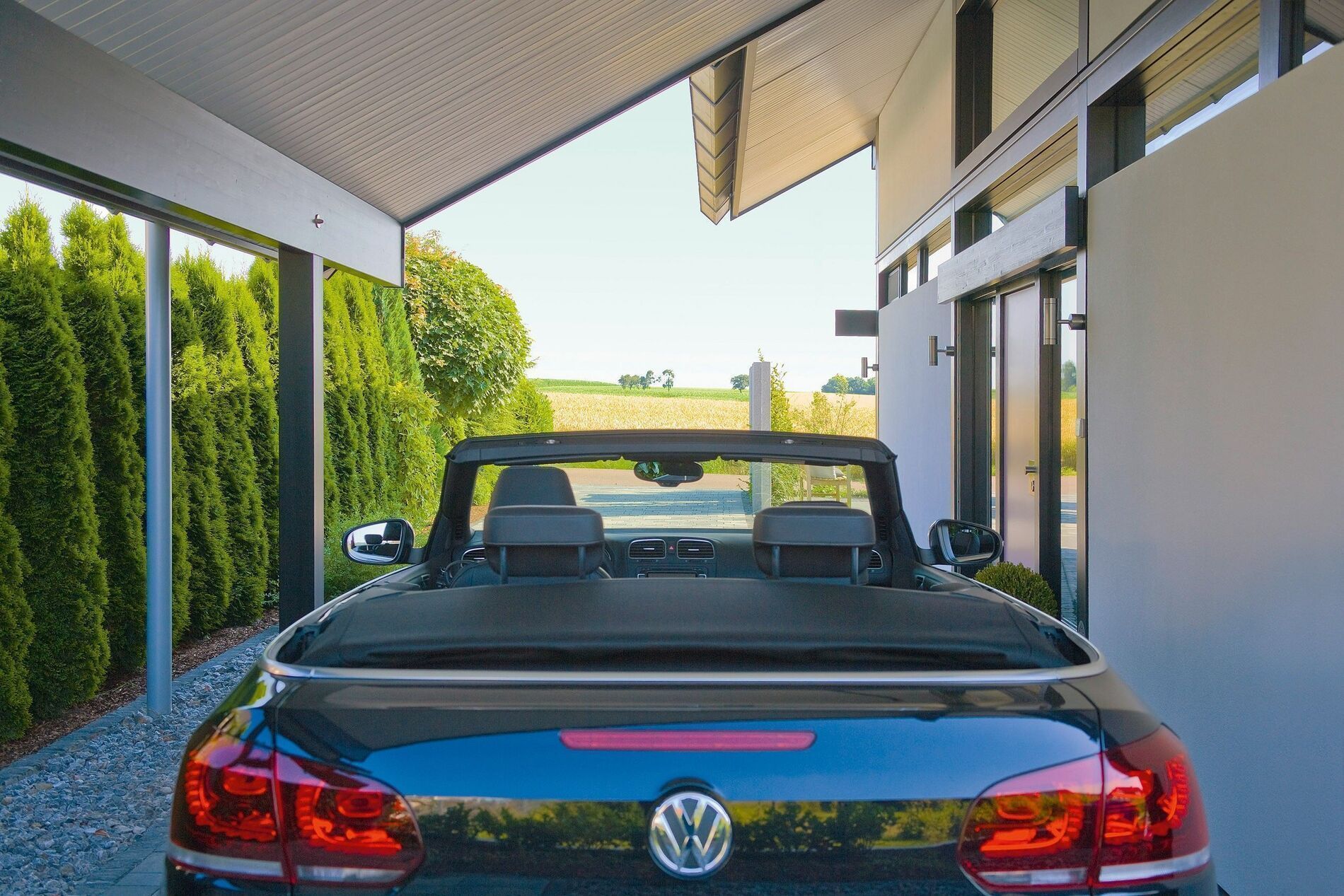 Eine Ansicht eines Architektenhauses mit einem schwarzen Cabrio im Vordergrund