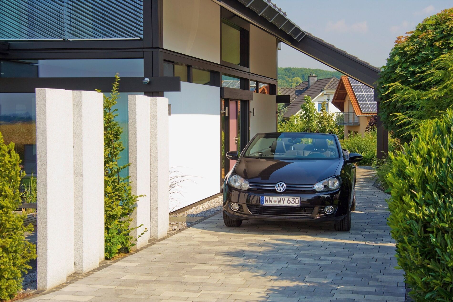 Architektenhaus mit schwarzem VW Golf in der Einfahrt