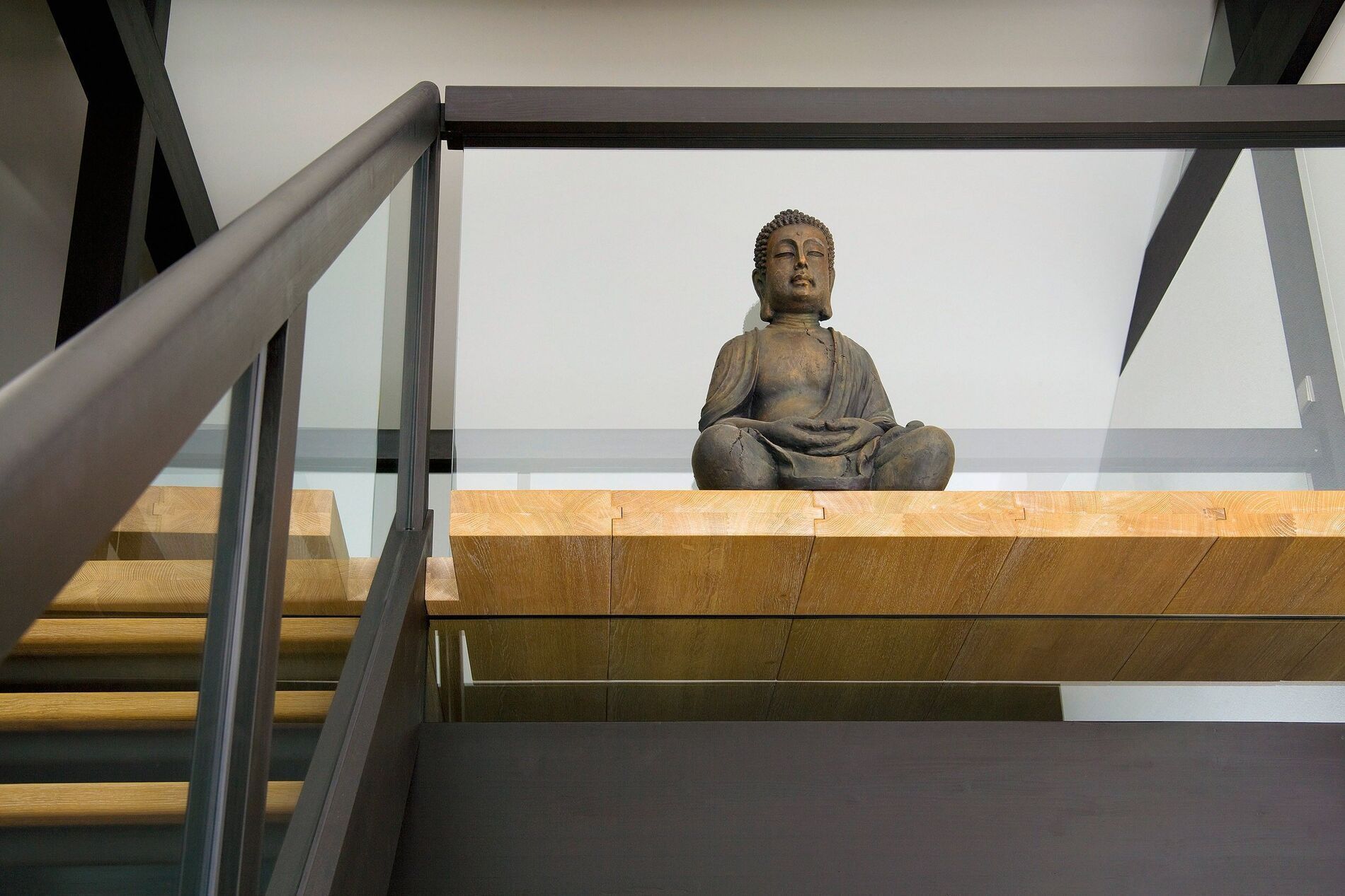 Innenansicht eines Architektenhauses mit Buddha-Skulptur und Holzdetails
