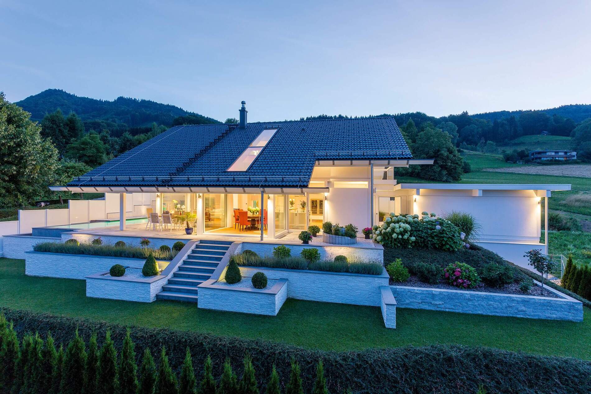 Moderne Architektur mit Blick auf Hügel und See bei Dämmerung