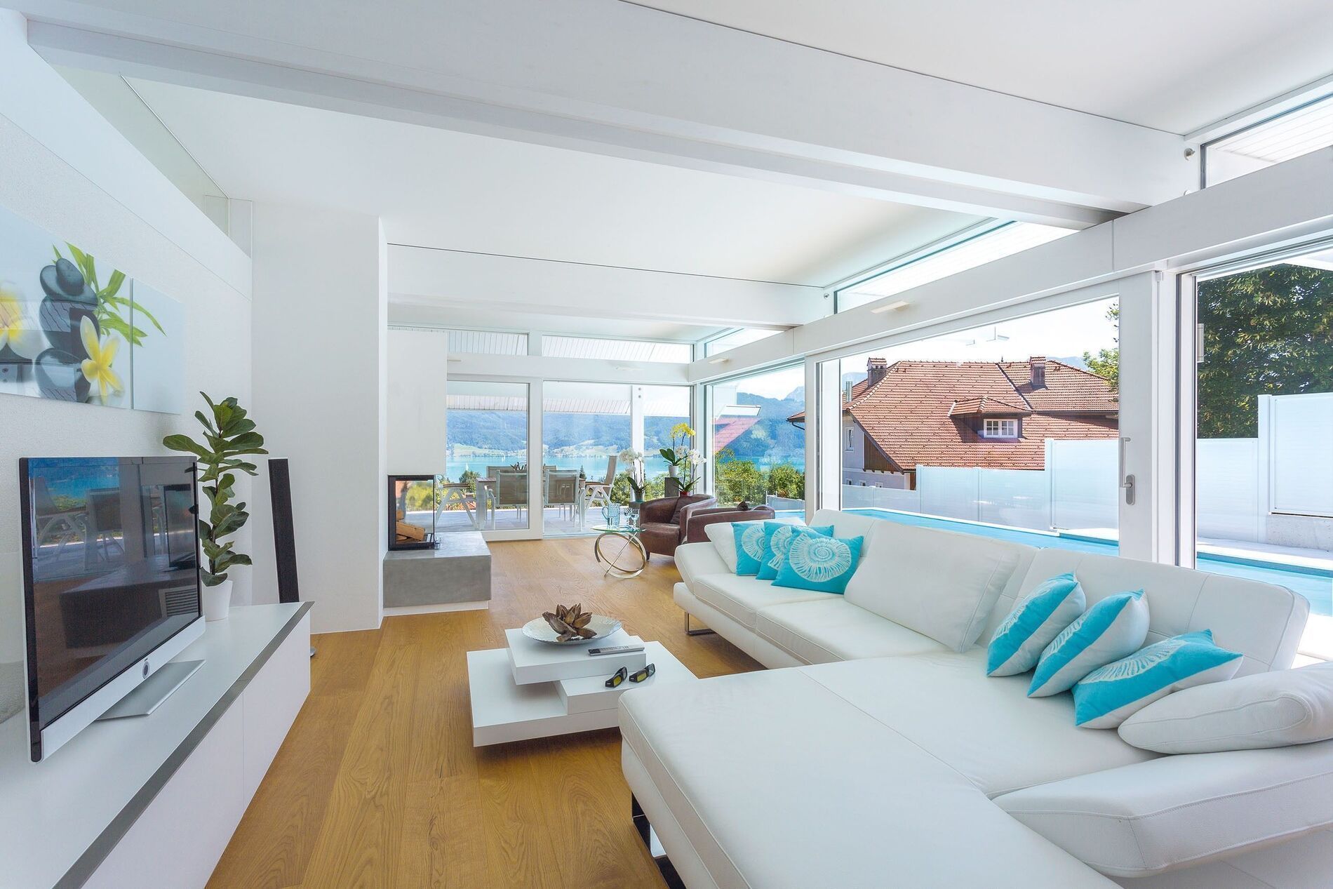 Helles Wohnzimmer mit Blick auf Landschaft und See durch große Fenster