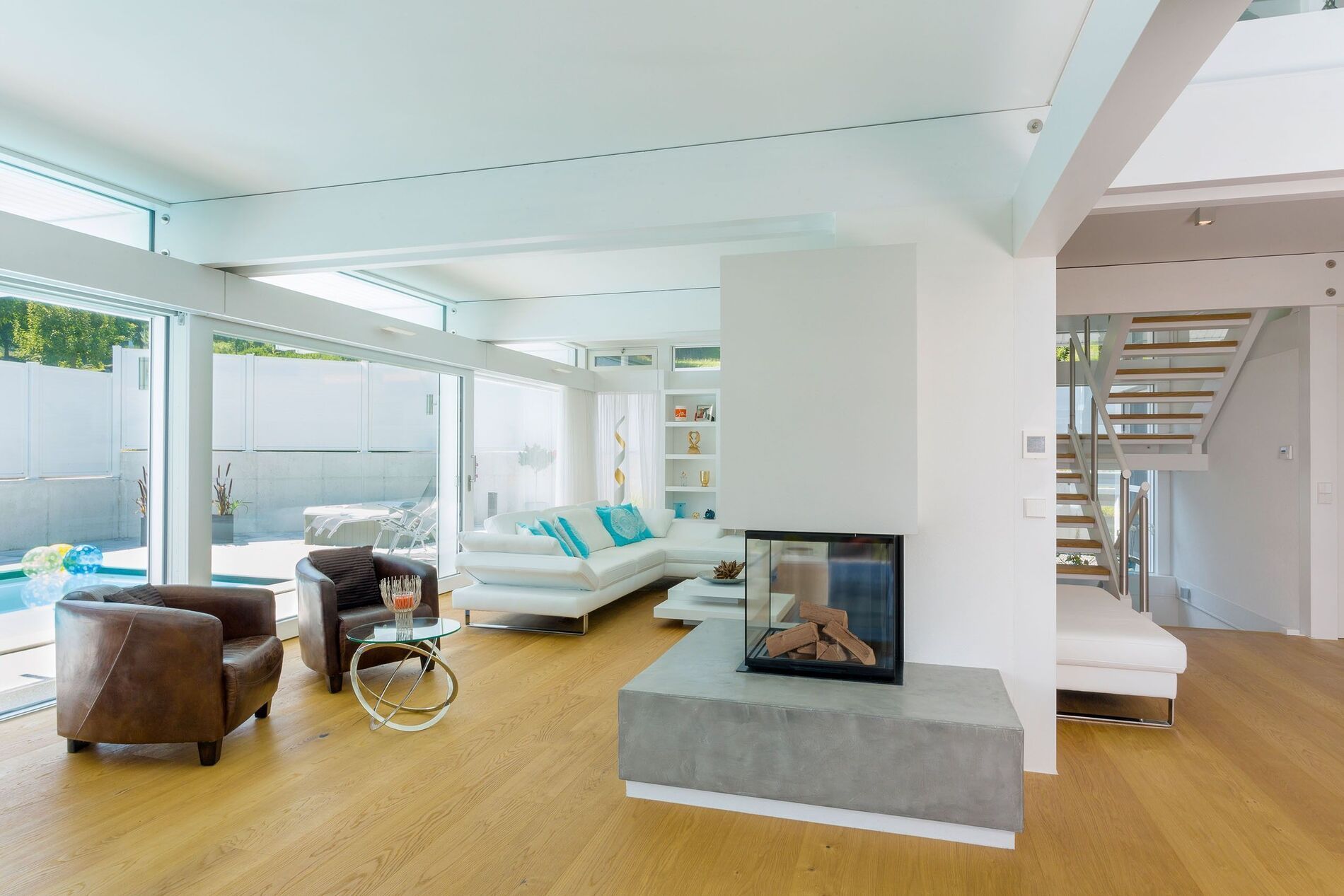Helles Wohnzimmer mit großflächigen Fenstern und moderner Einrichtung