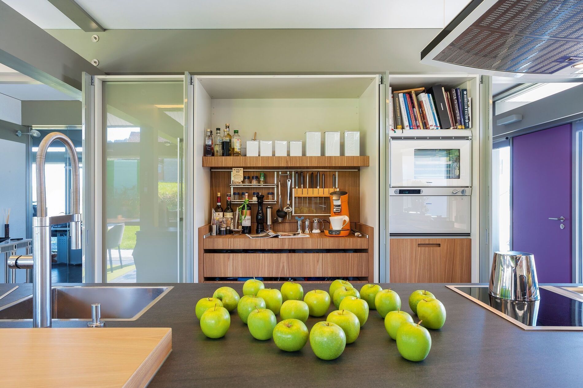 Einblick in eine moderne Küche mit großzügigem Design und grünen Äpfeln