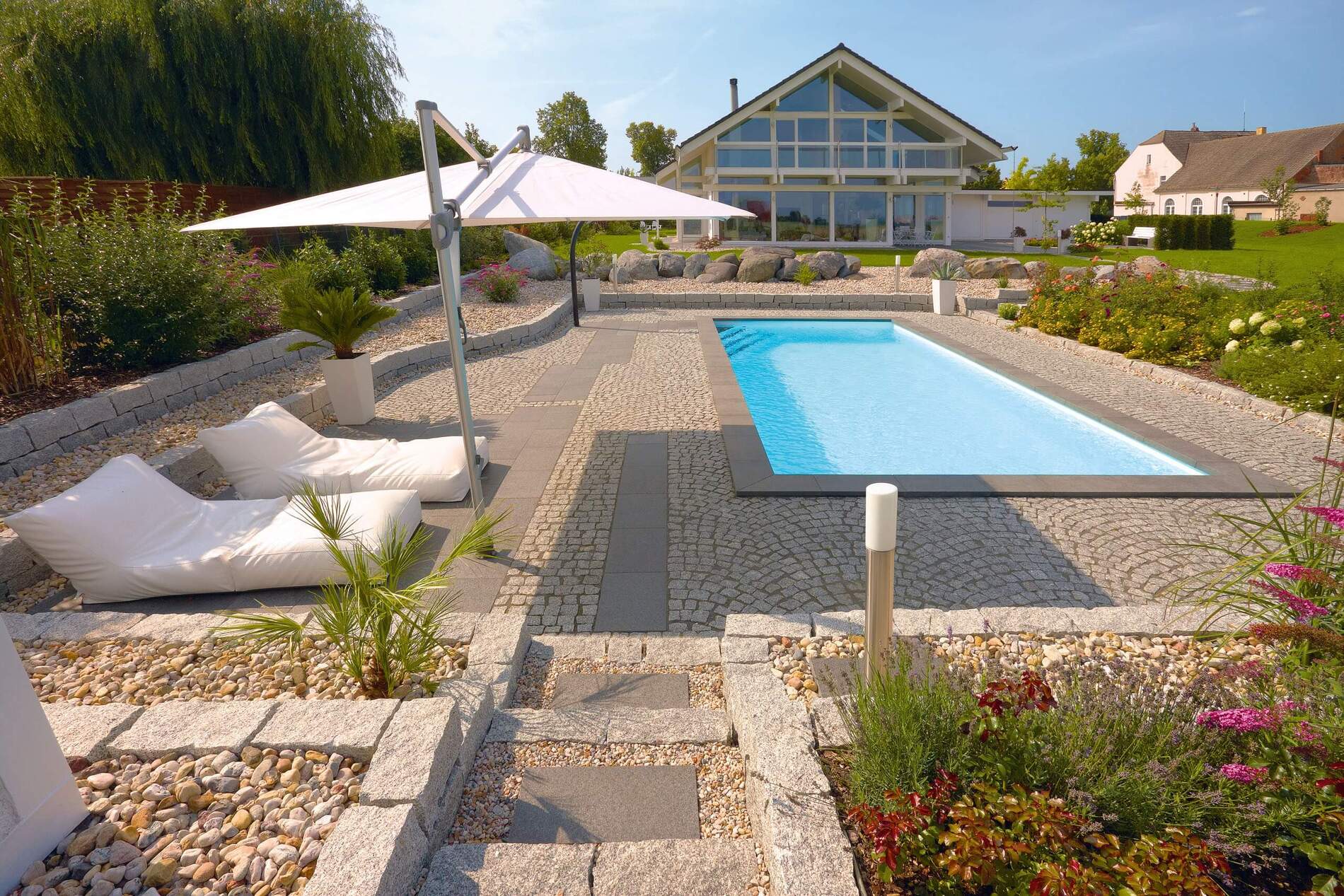Schön gestalteter Garten mit Pool und modernen Sitzgelegenheiten