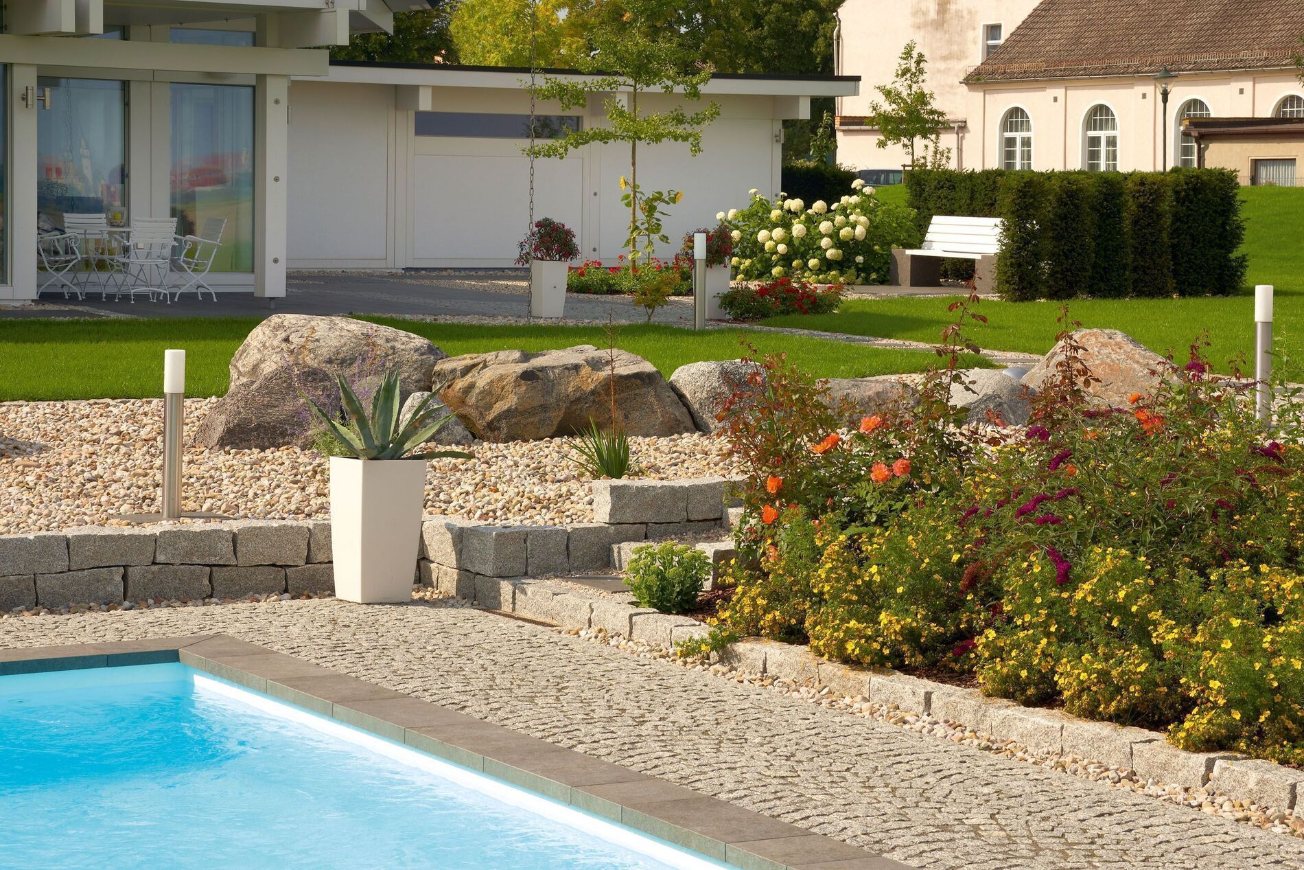 Moderne Architektur mit Natursteinen und Gartenblumen