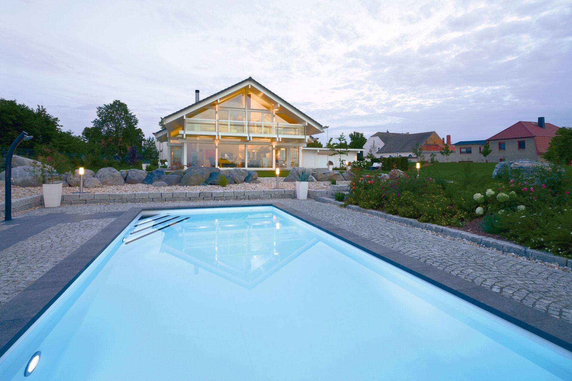 Moderne Architektur eines HUF Hauses mit Pool und Gartenlandschaft