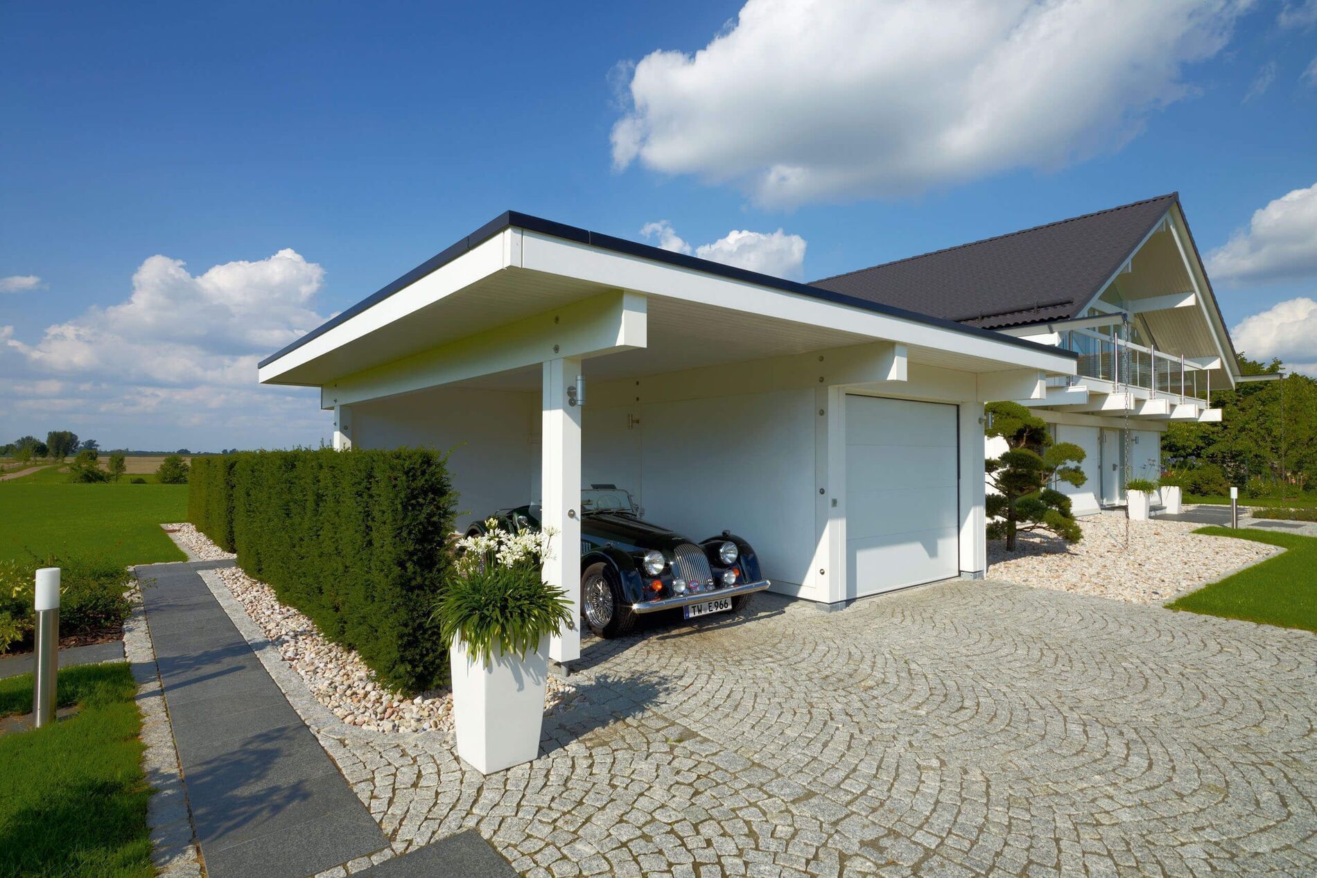 Modernes Fachwerkhaus mit Carport und Gartenlandschaft