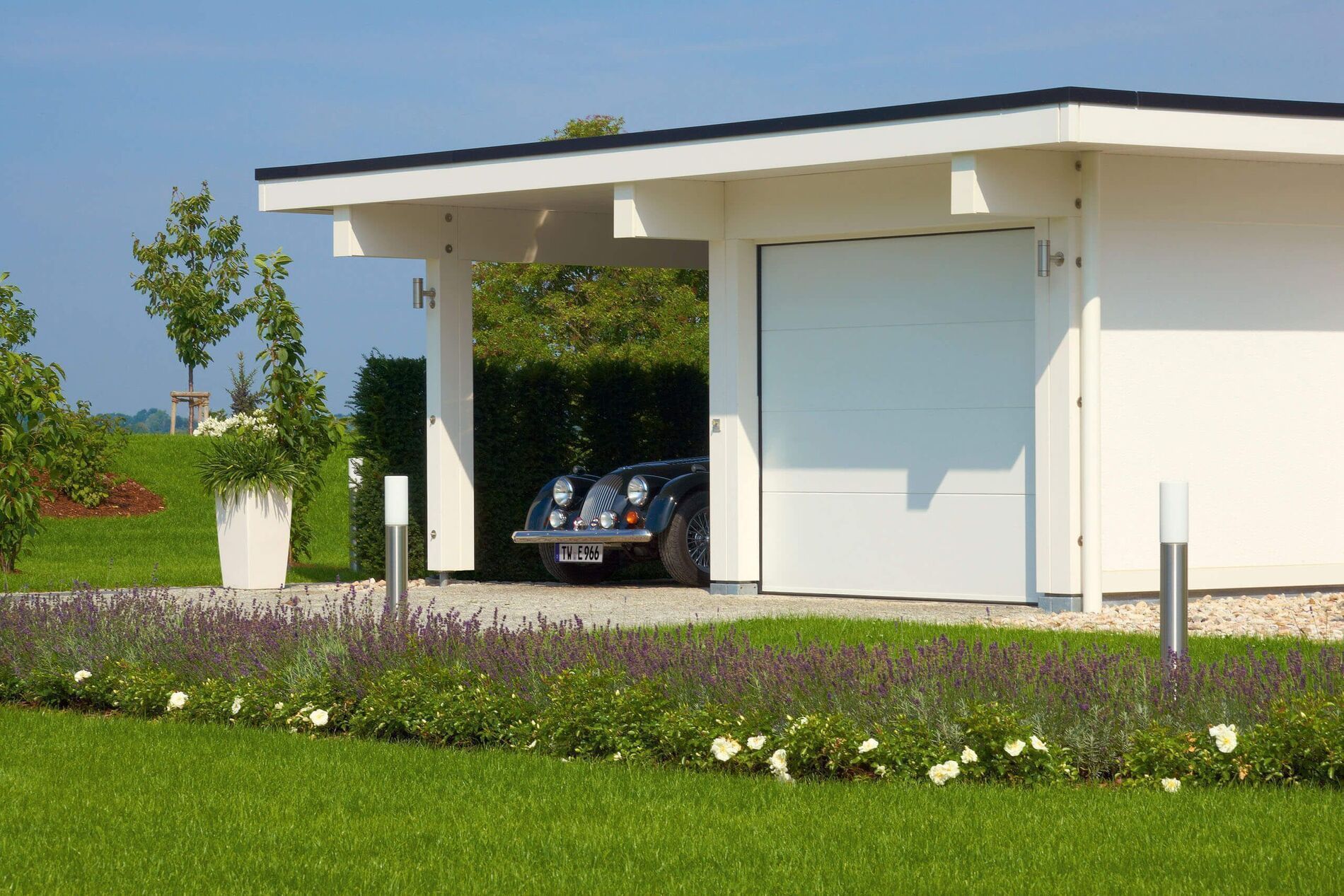 Moderne Architektur eines Fachwerkhauses mit Carport und Garten.