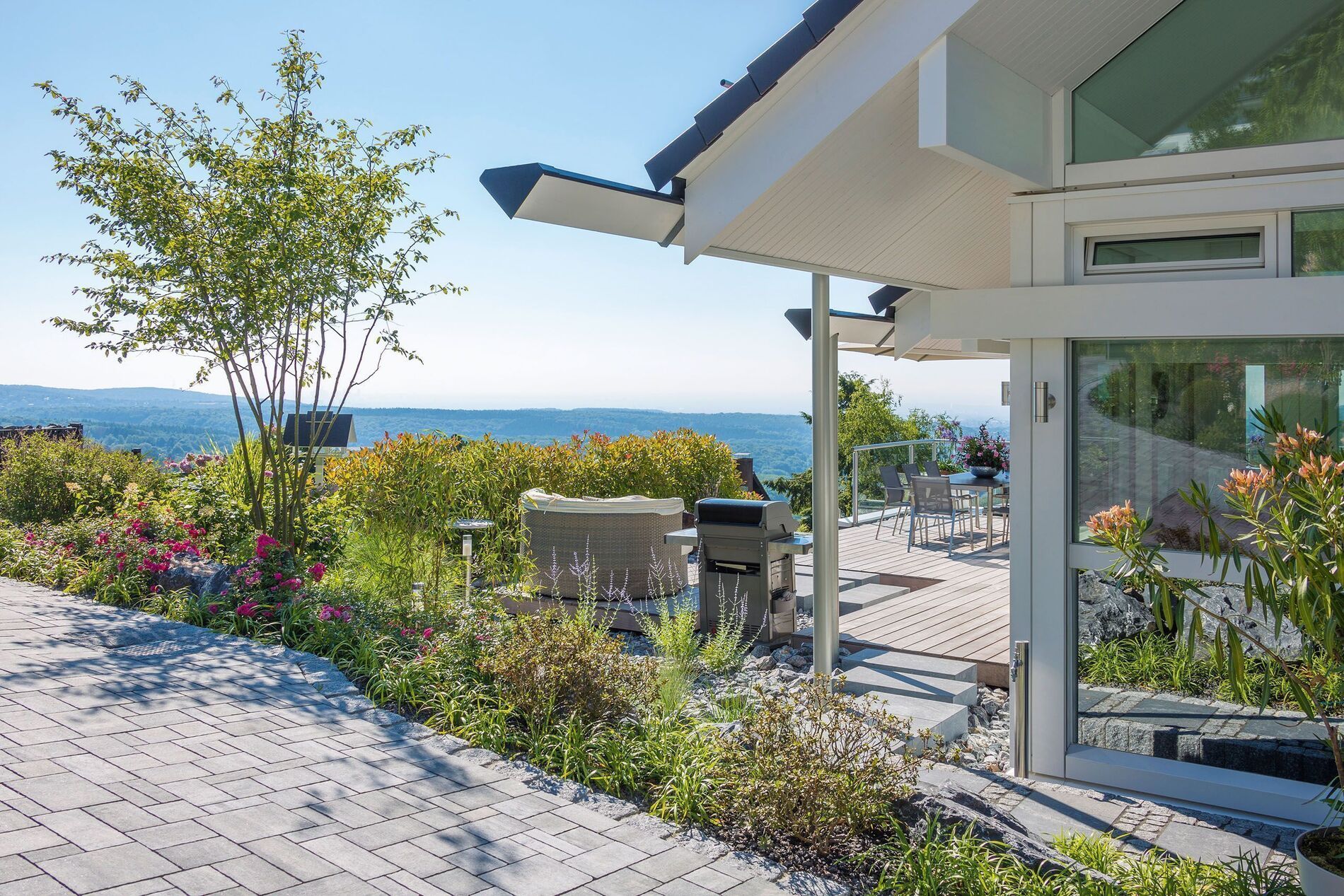 Moderner Garten mit Blick auf Wasser und stilvollem Designhaus
