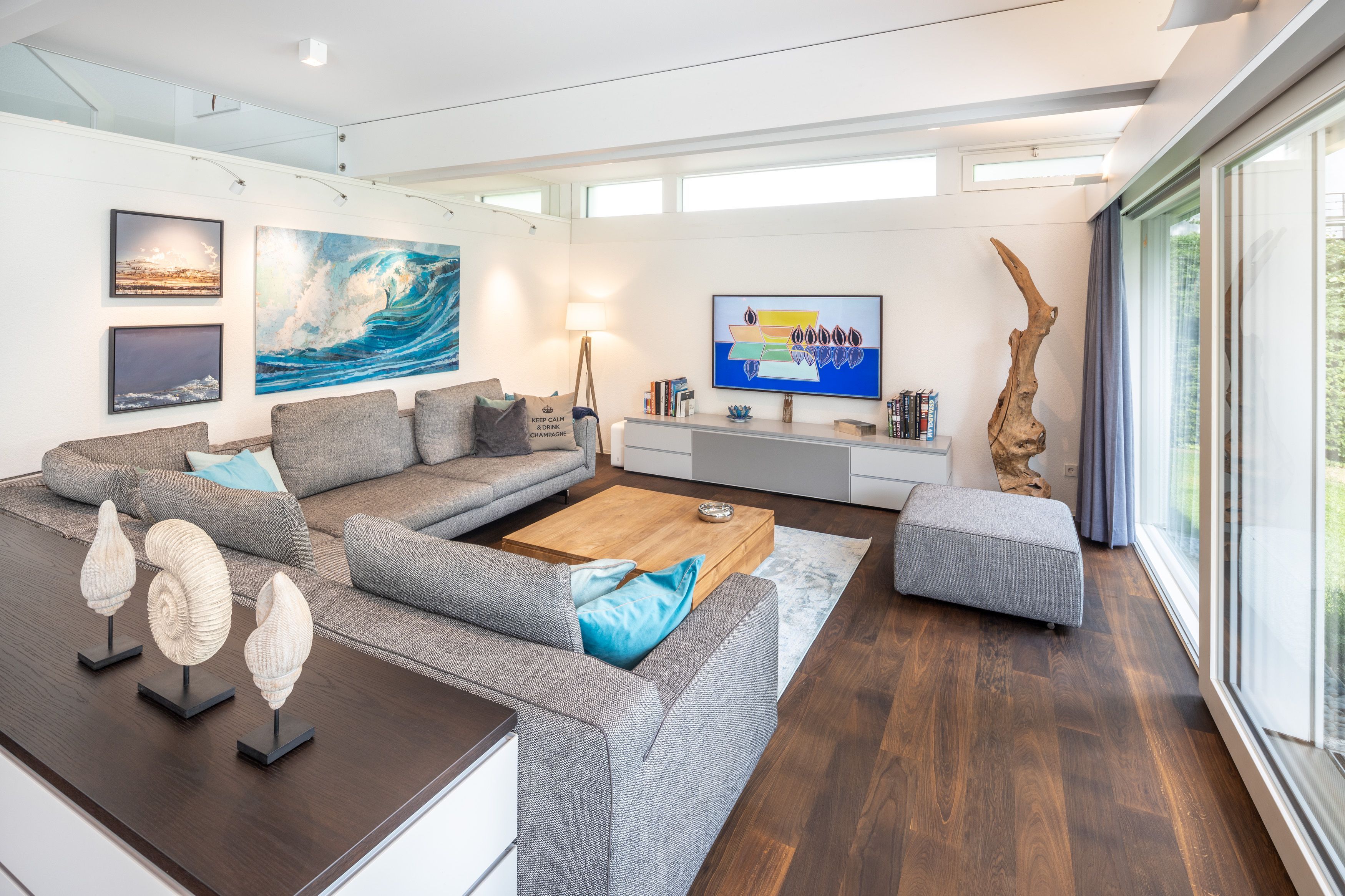 Heller Wohnraum mit gemütlicher Sofa-Landschaft und Kunstwerken
