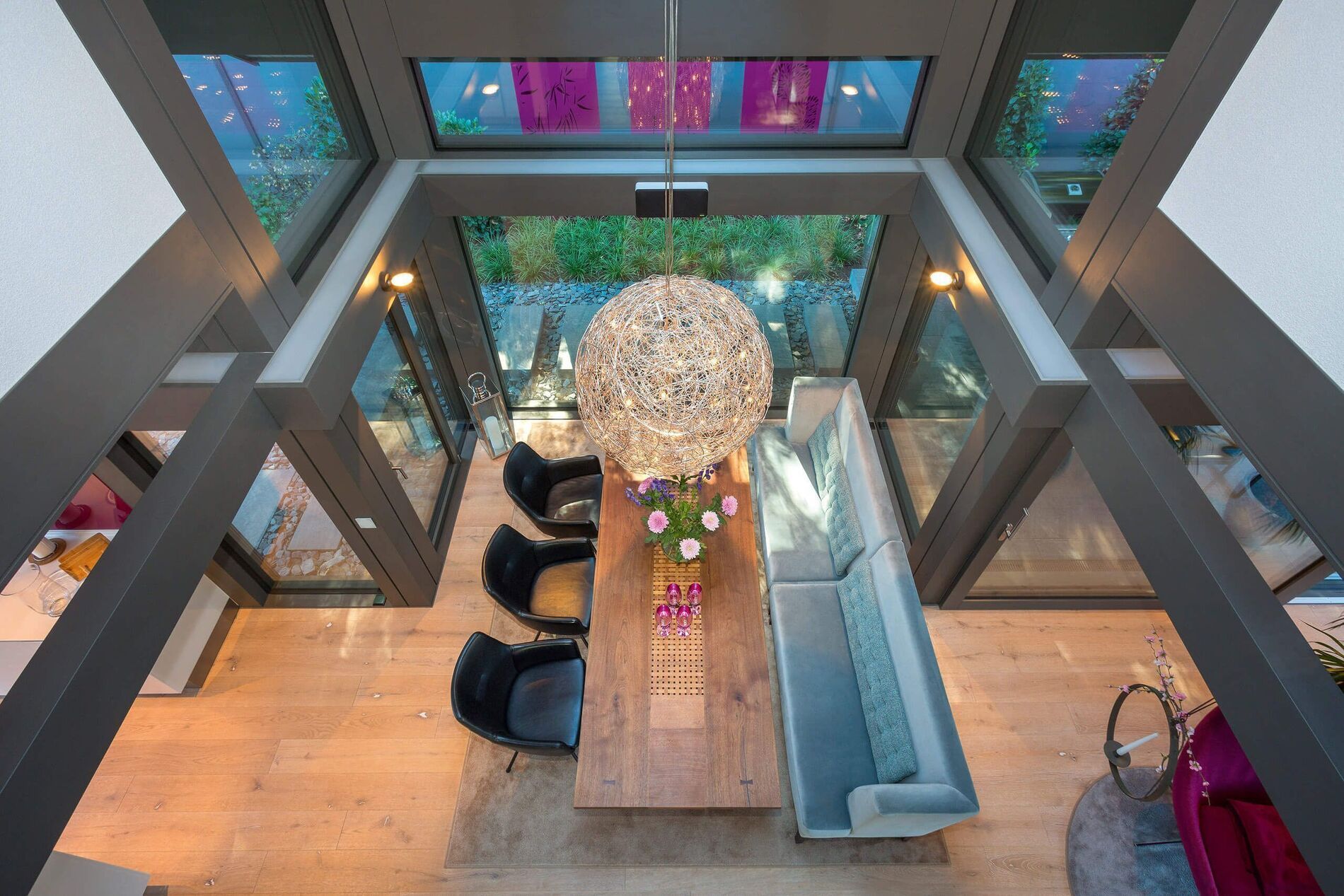 Überblick über ein stilvolles, modernes Wohnzimmer mit großem Tisch und natürlichen Materialien