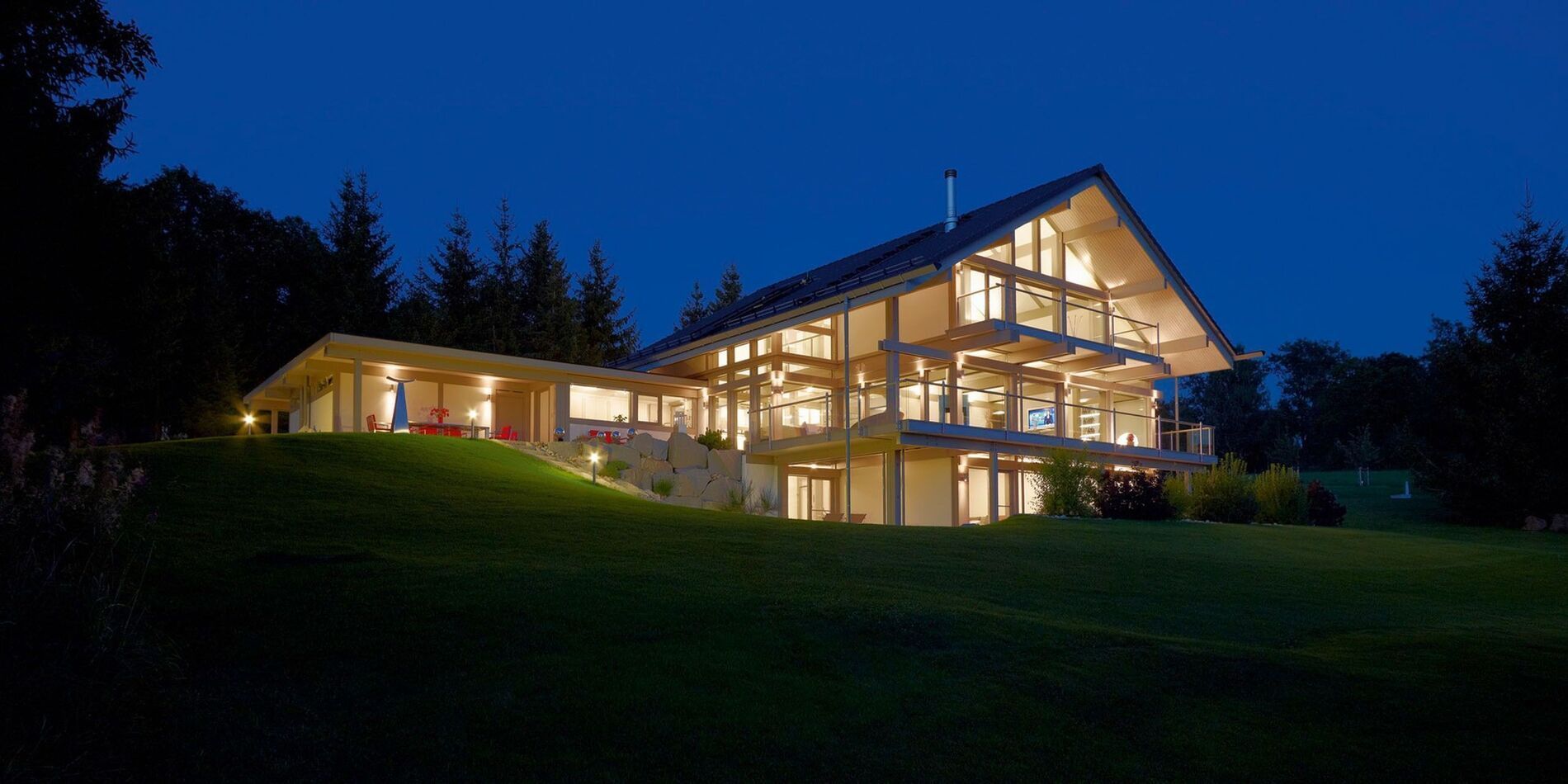 Energieeffizientes Architektenhaus mit großzügigen Glasflächen bei Nacht