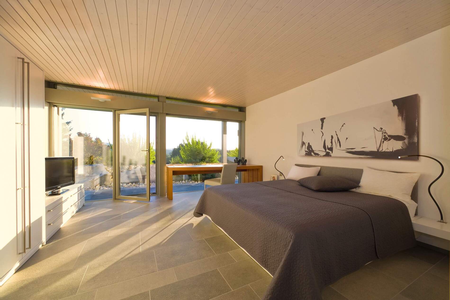 Modernes Schlafzimmer mit großen Glasflächen und eleganter Ausstattung