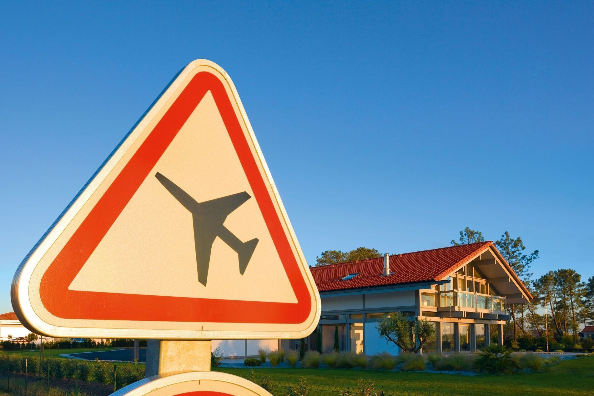 HUF Haus mit Flugzeughanger HUF Haus neben einem Verkehrsschild für Flugzeuge
