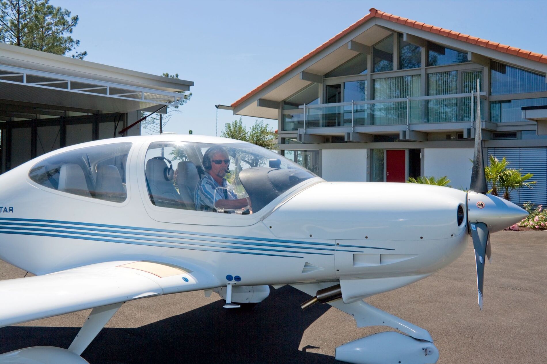 Moderne HUF Haus mit Flugzeughangar Flugzeug vor einem stilvollen HUF Haus mit Hangar
