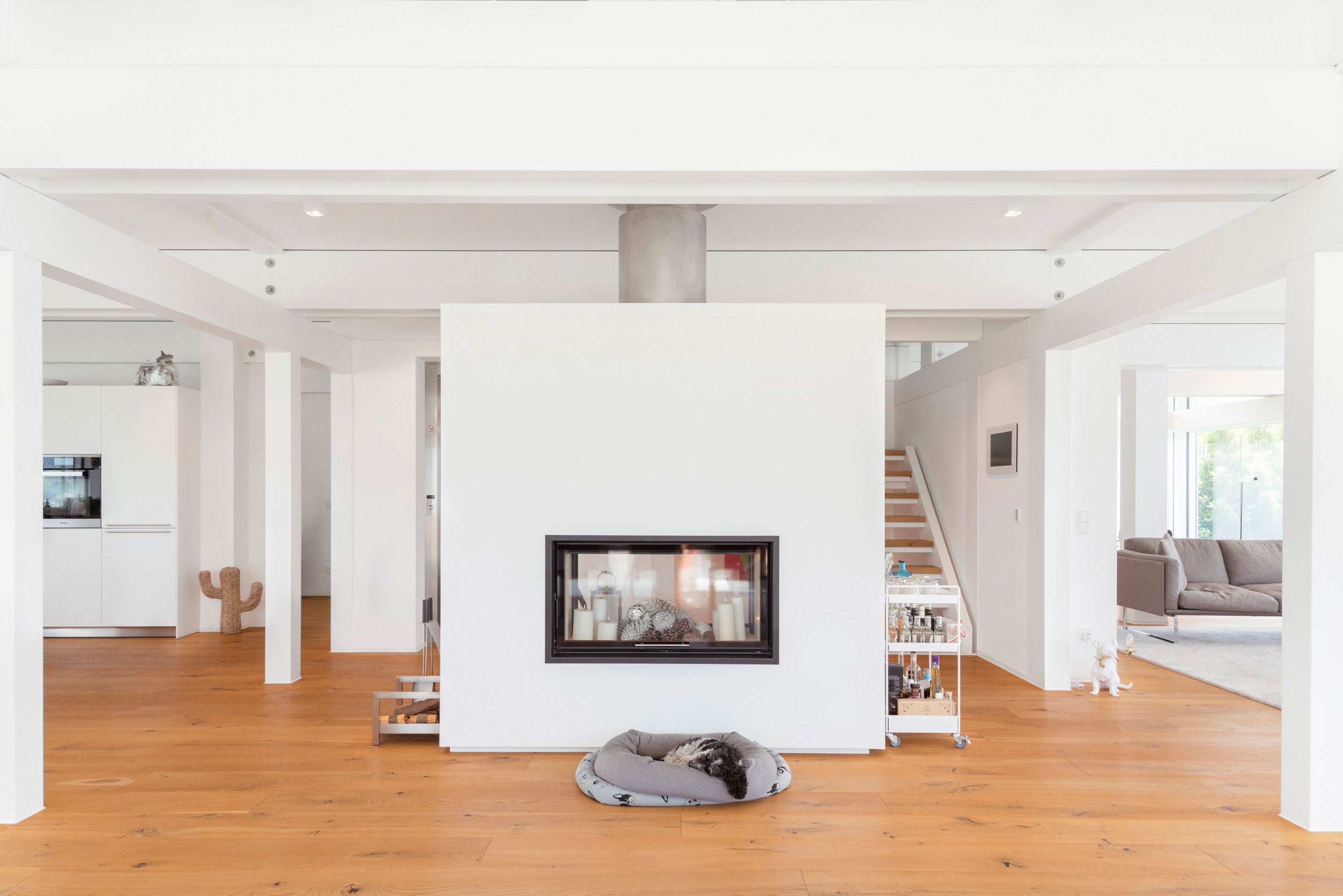 Helles Interieur mit zentralem Kamin und Holzfußboden