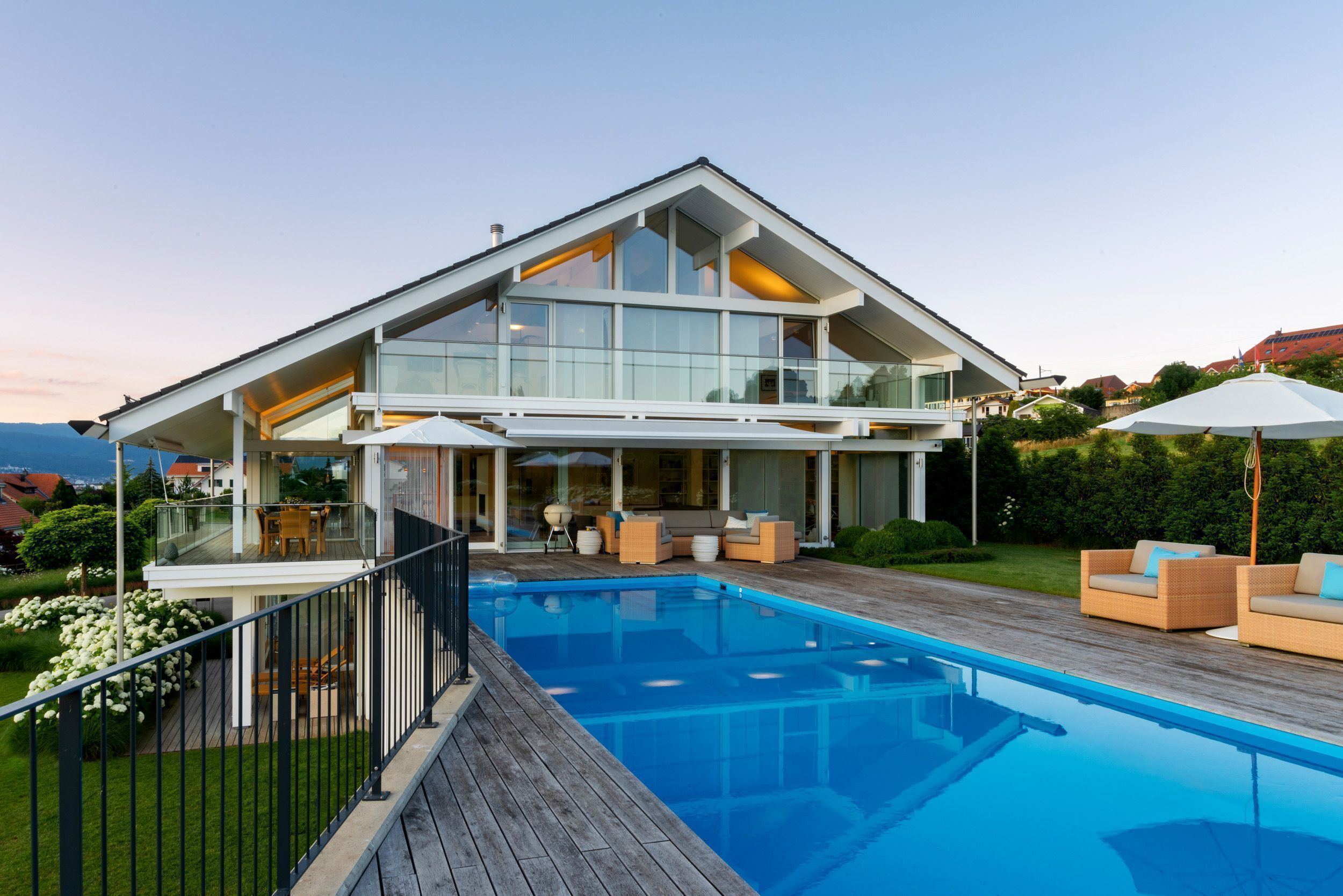 Ein stilvolles Haus mit Glaselementen und einem Swimmingpool im Garten