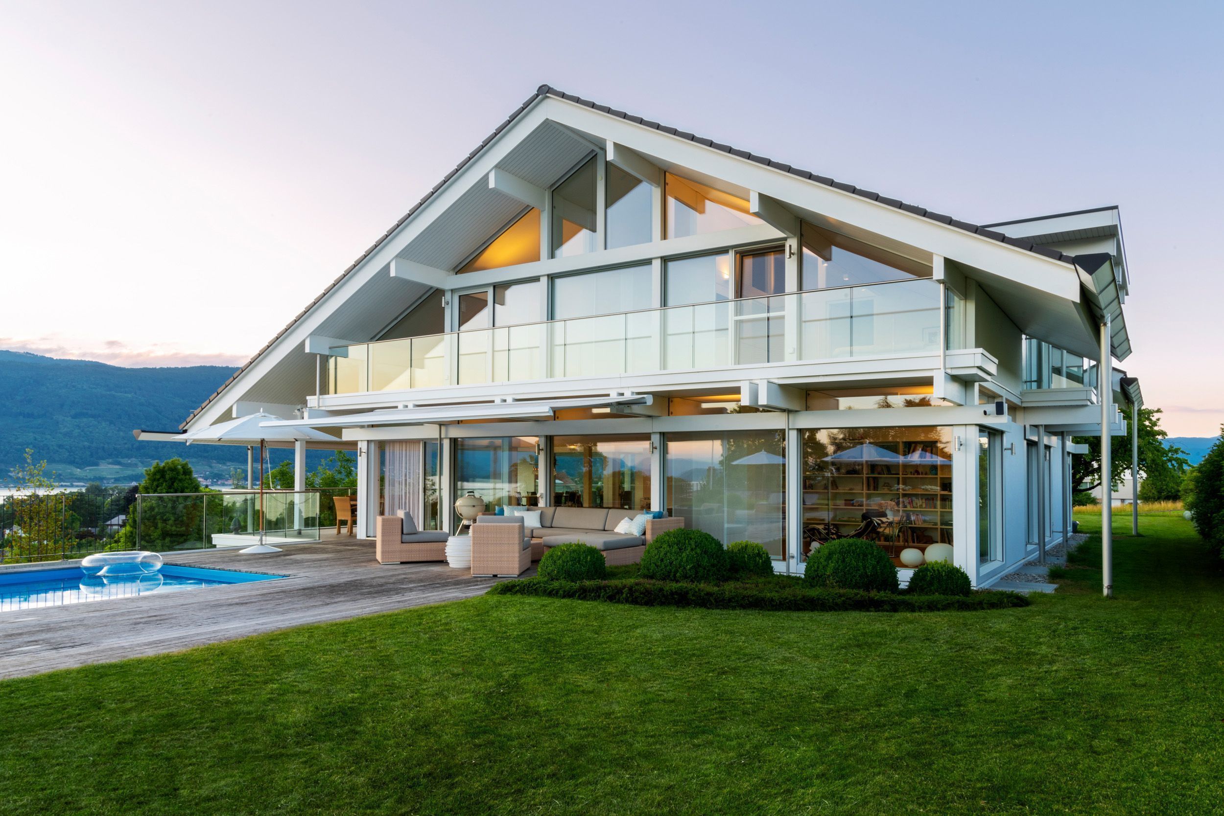 Elegantes Designhaus mit großen Fenstern und einem Pool im Garten