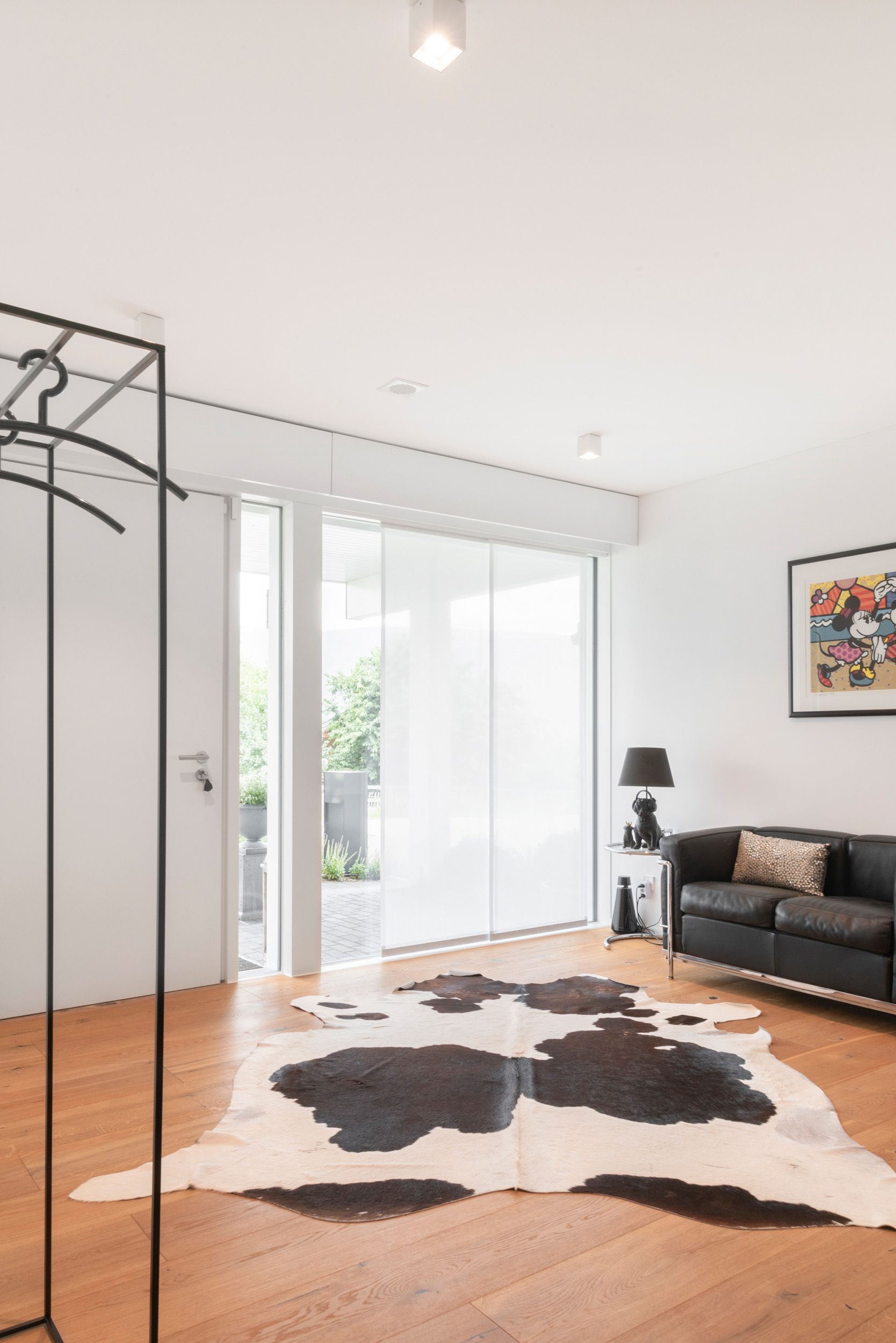 Geräumiger Raum mit schwarzem Sofa und Cowhide-Teppich