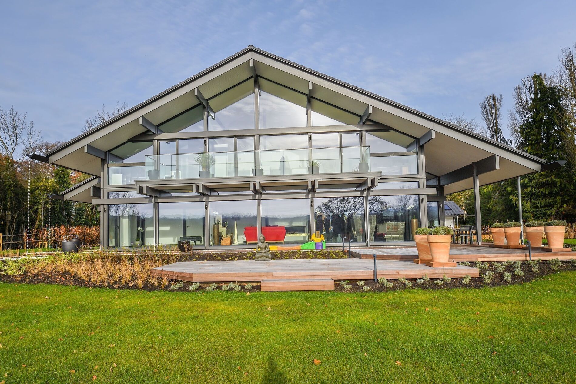Modernes HUF Haus mit großen Fenstern und gepflegtem Garten