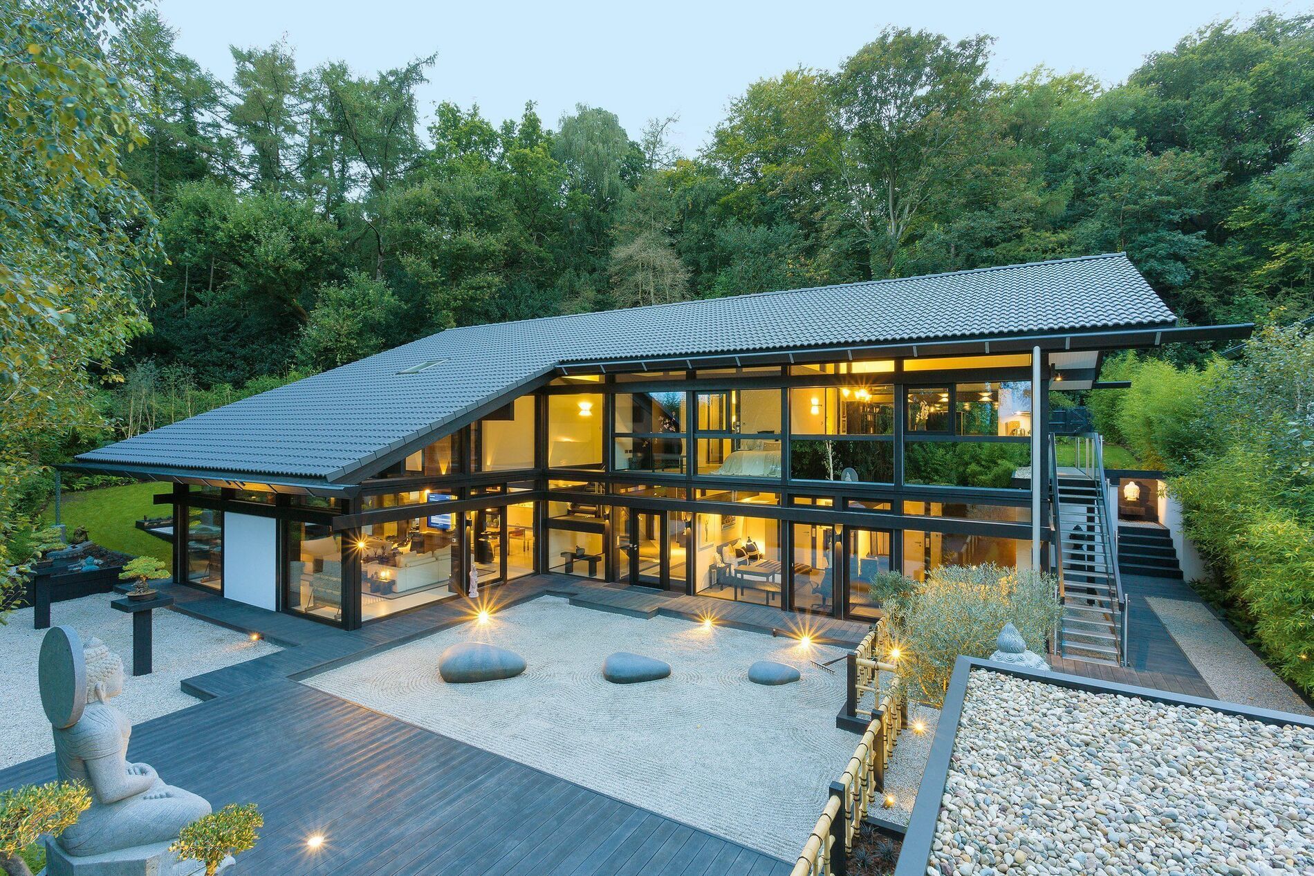 HUF Haus mit Doppelpultdach, Glasfassade und Außenpool in Naturumgebung