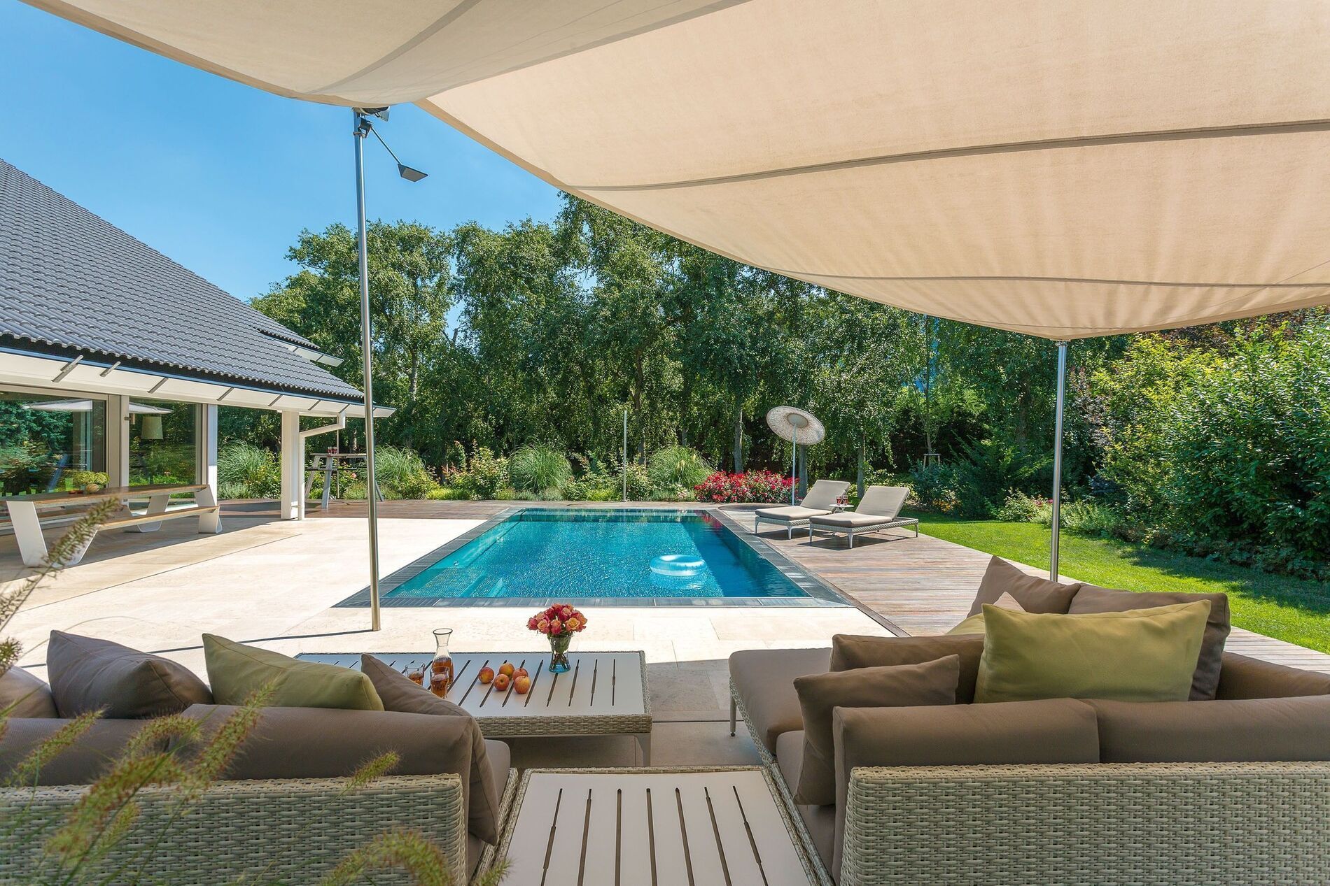 Blick auf den Poolbereich eines modernen Hauses mit Lounge-Möbeln