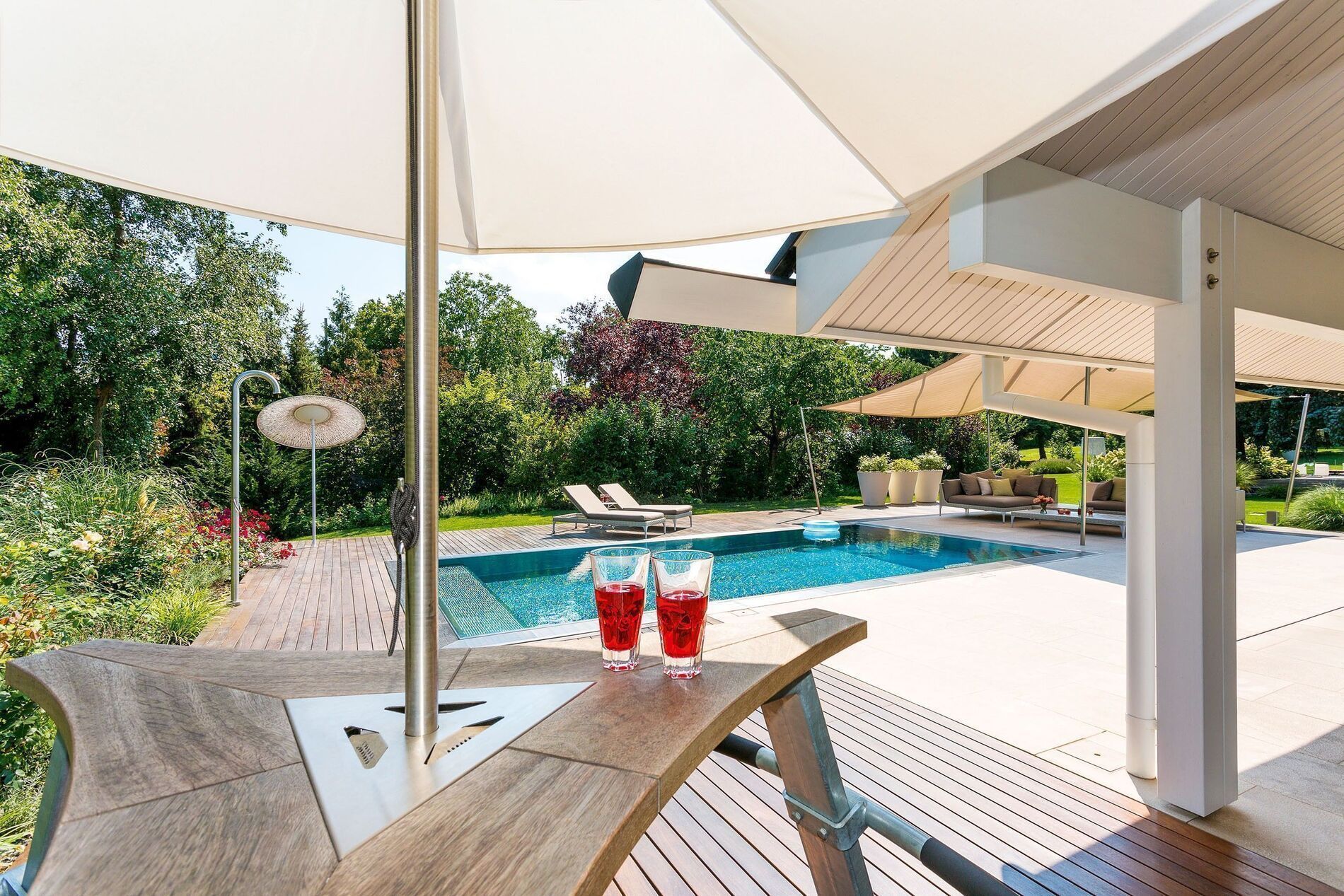 Moderne Terrasse mit Blick auf den Pool in einem schönen Garten