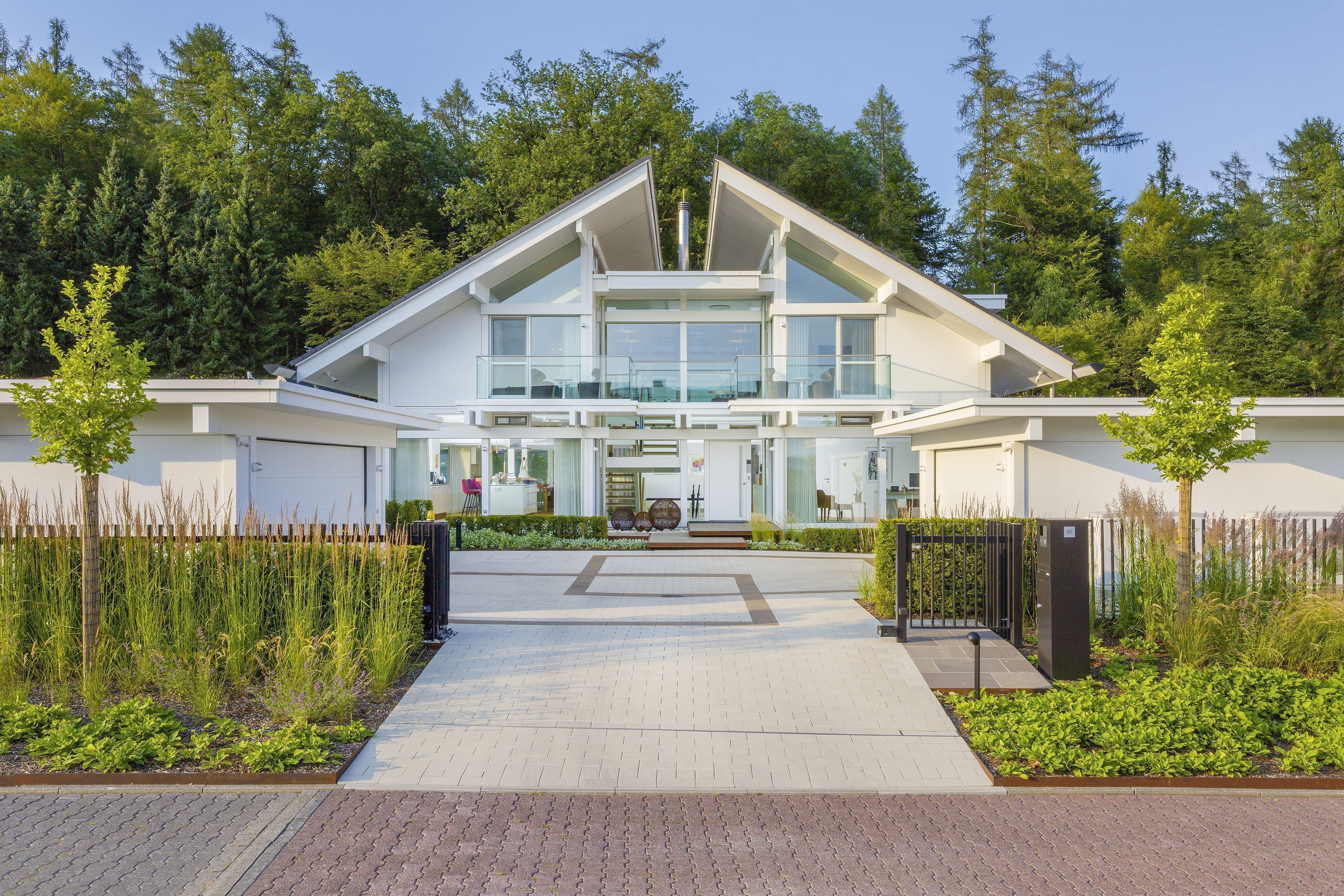 Ansicht einer eleganten Villa mit gläserner Fassade und Garten