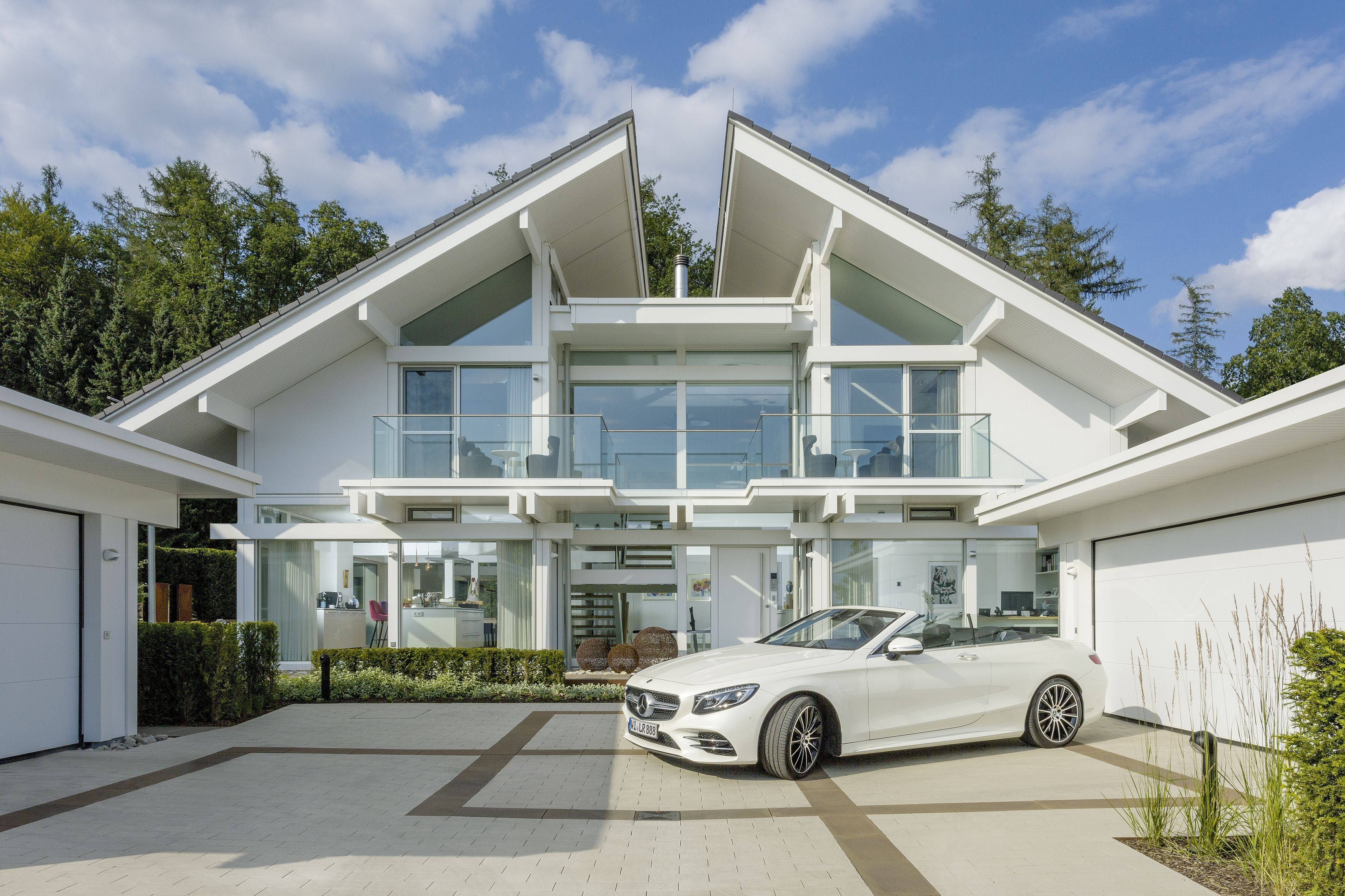 Architektonische Facade einer modernen Villa mit Garten und Auto