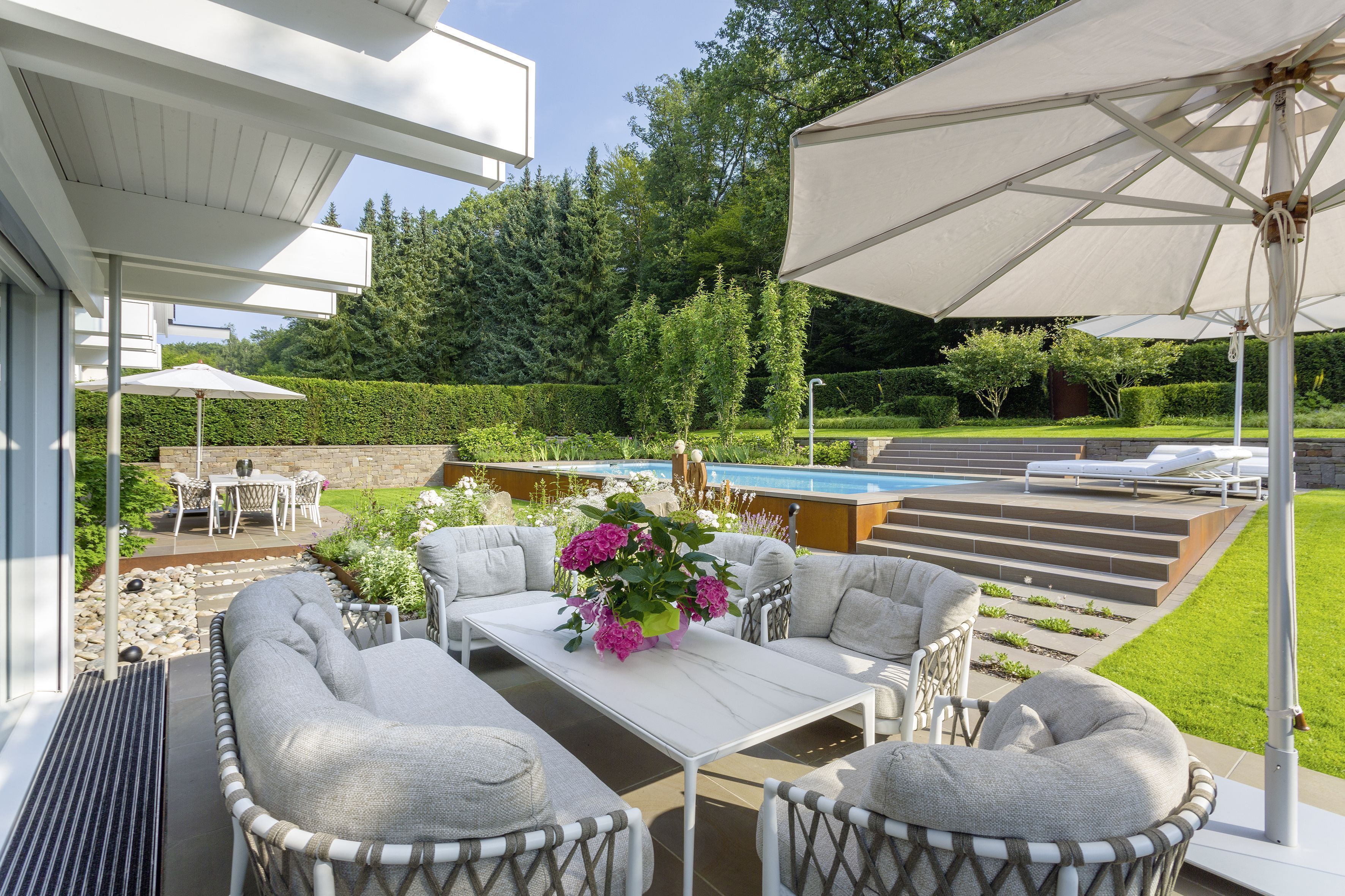Außenansicht einer Fachwerk-Villa mit schönem Garten und Sitzbereich
