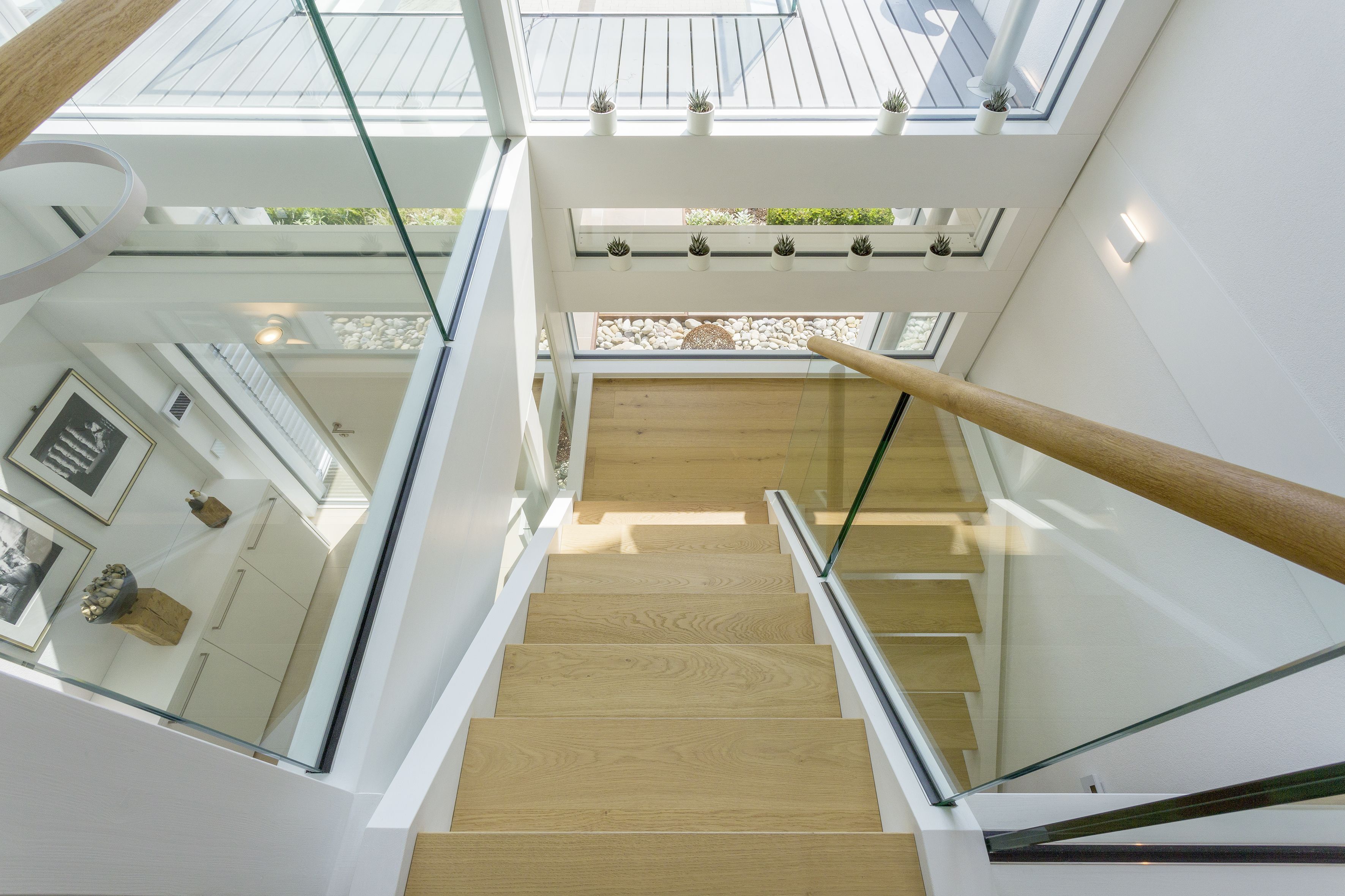 Blick von oben auf das Treppenhaus einer modernen Villa mit Glasdetails