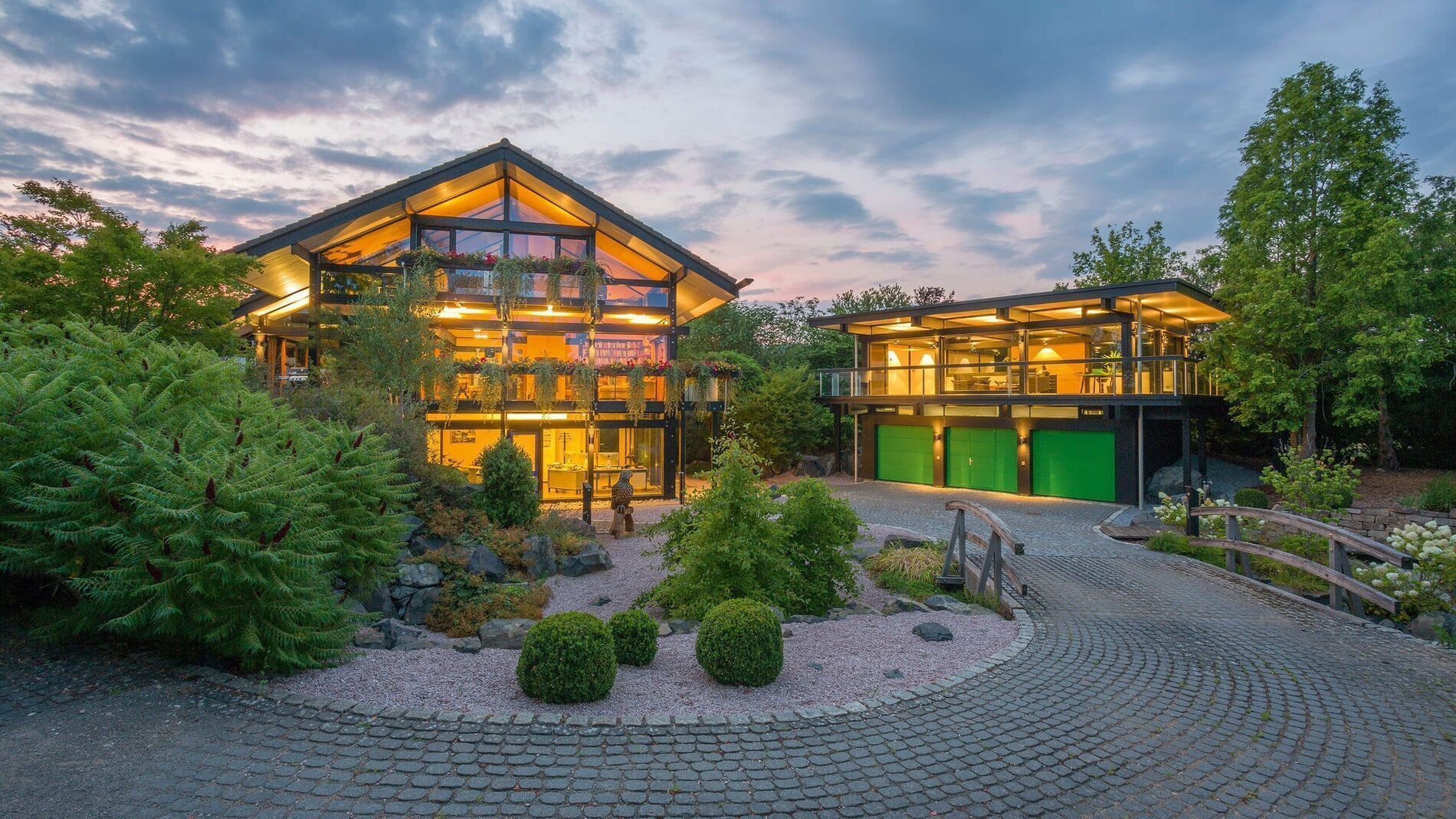 HUF Haus mit Dreifach-Garage und Bürogebäude Haus mit großer Garage und Bürogebäude bei Sonnenuntergang