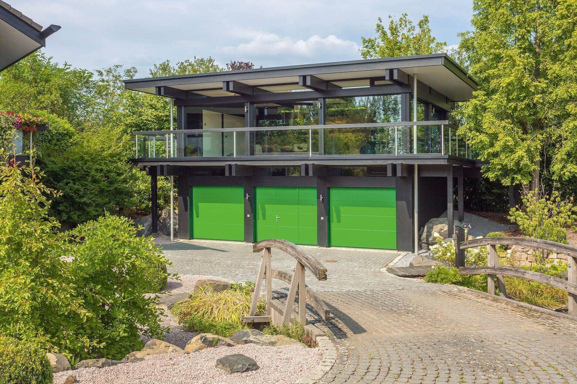 HUF Haus mit Dreifach-Garage und Bürogebäude Modernes HUF Haus mit grünen Garagentoren und Bürogebäude