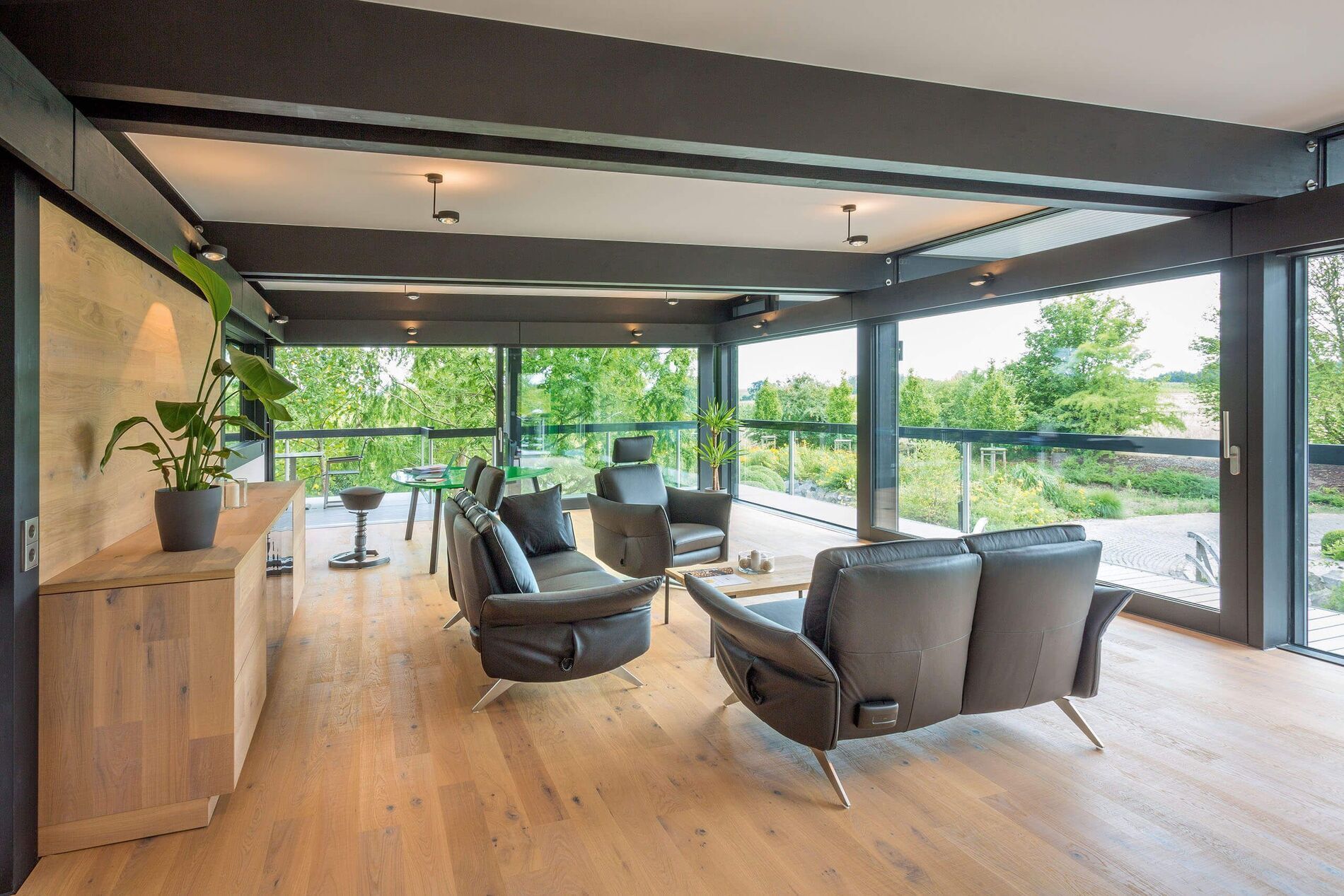 Moderne Inneneinrichtung eines HUF Hauses Lichtdurchfluteter Wohnbereich mit modernen Möbeln und Blick ins Grüne