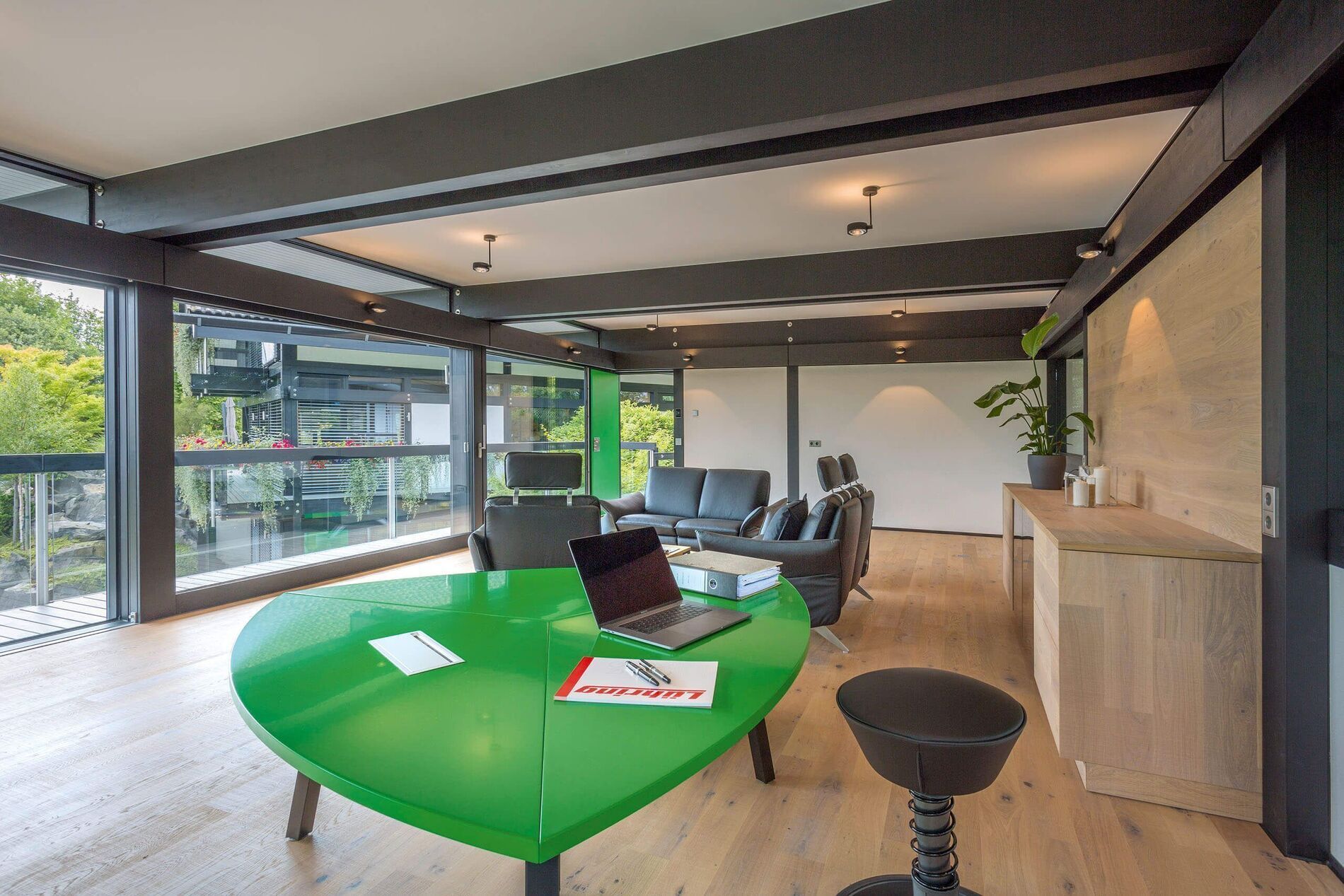 Modernes HUF Haus mit Dreifach-Garage und Büro Innenansicht eines modernen HUF Hauses mit grünem Tisch und Bürobereich