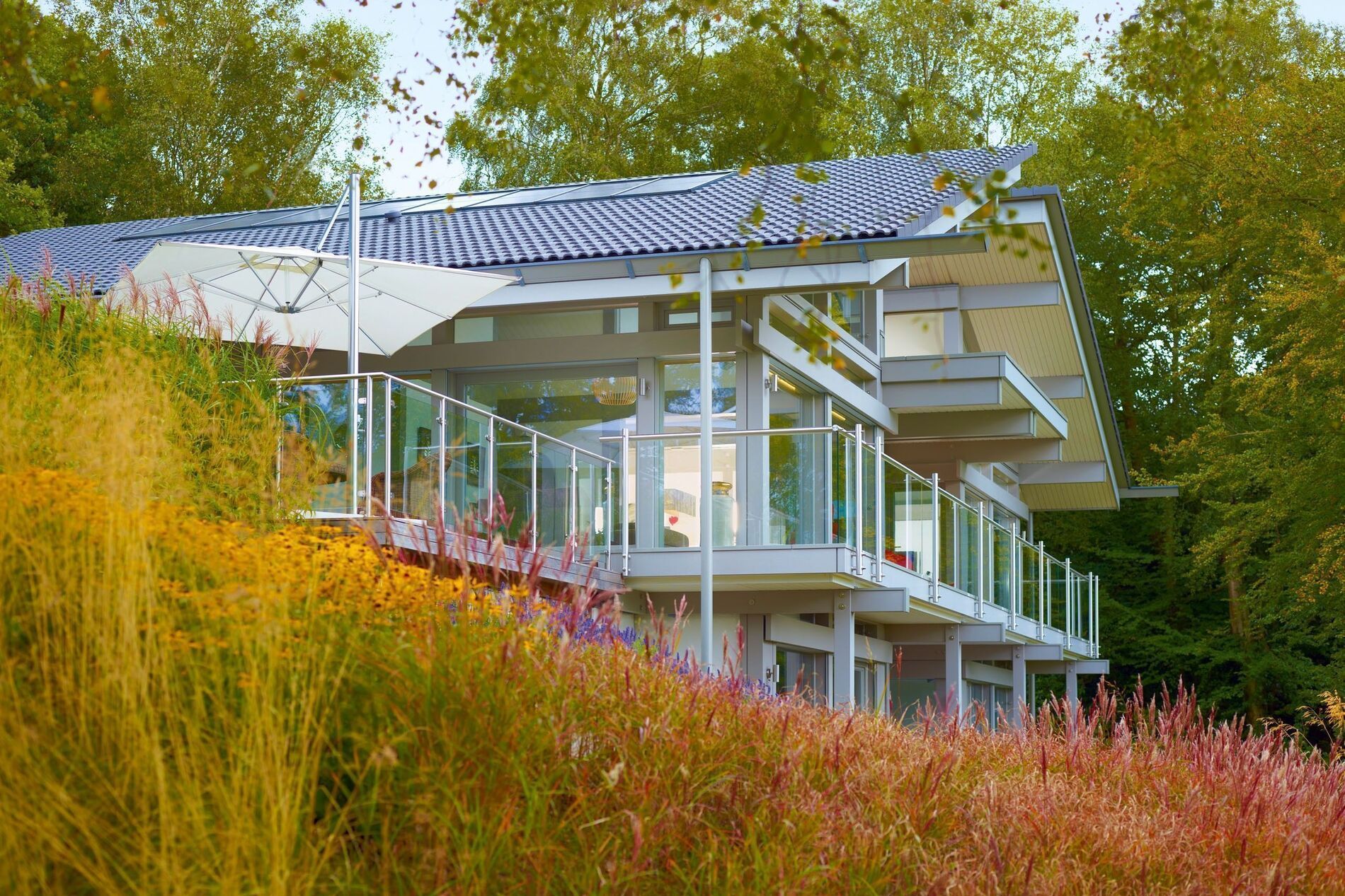 Eleganter Bungalow in Natur, umgeben von bunten Blumen und Bäumen.