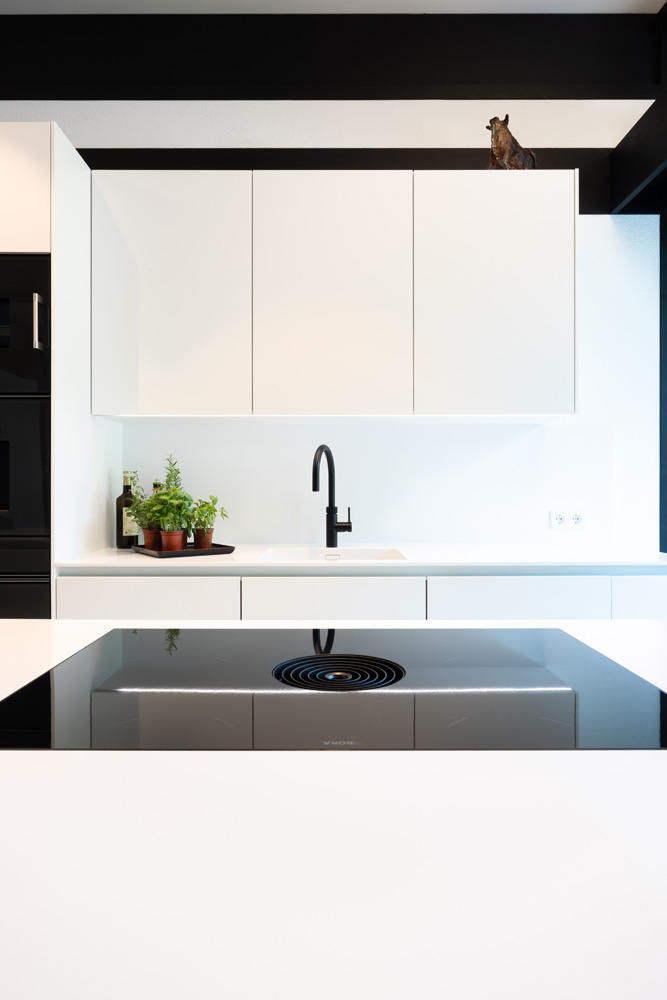 Hochmoderne Küche mit minimalistischen weißen Möbeln und Pflanzen