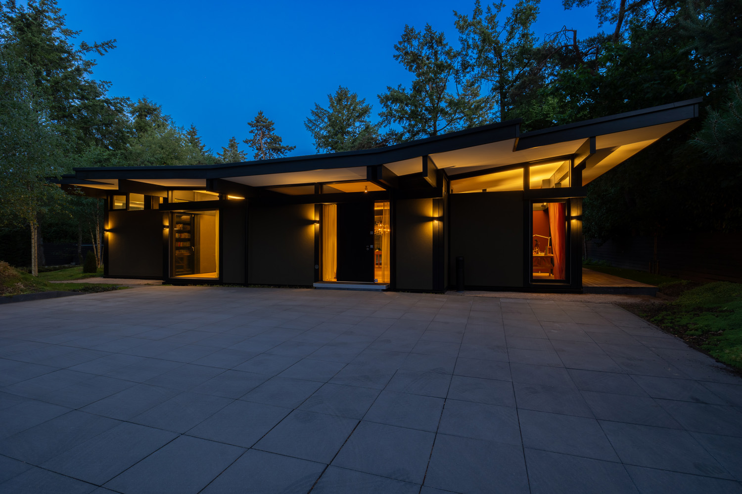 Ein traumhaftes modernes Bungalow mit stilvollem Design und beleuchtetem Eingang