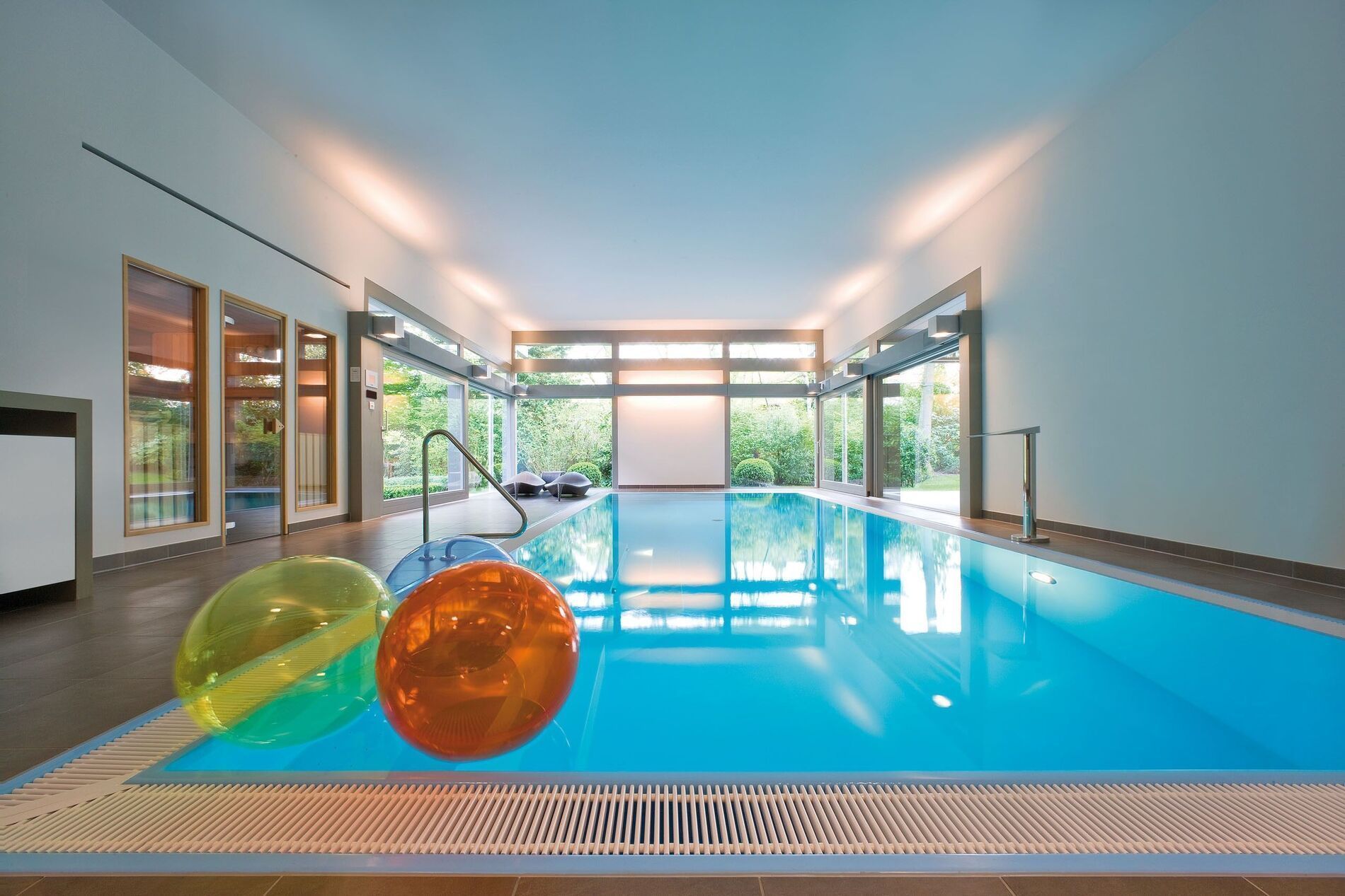 Modernes Flachdachhaus mit Swimmingpool Innenansicht eines modernen Schwimmbereichs mit bunten Wasserbällen