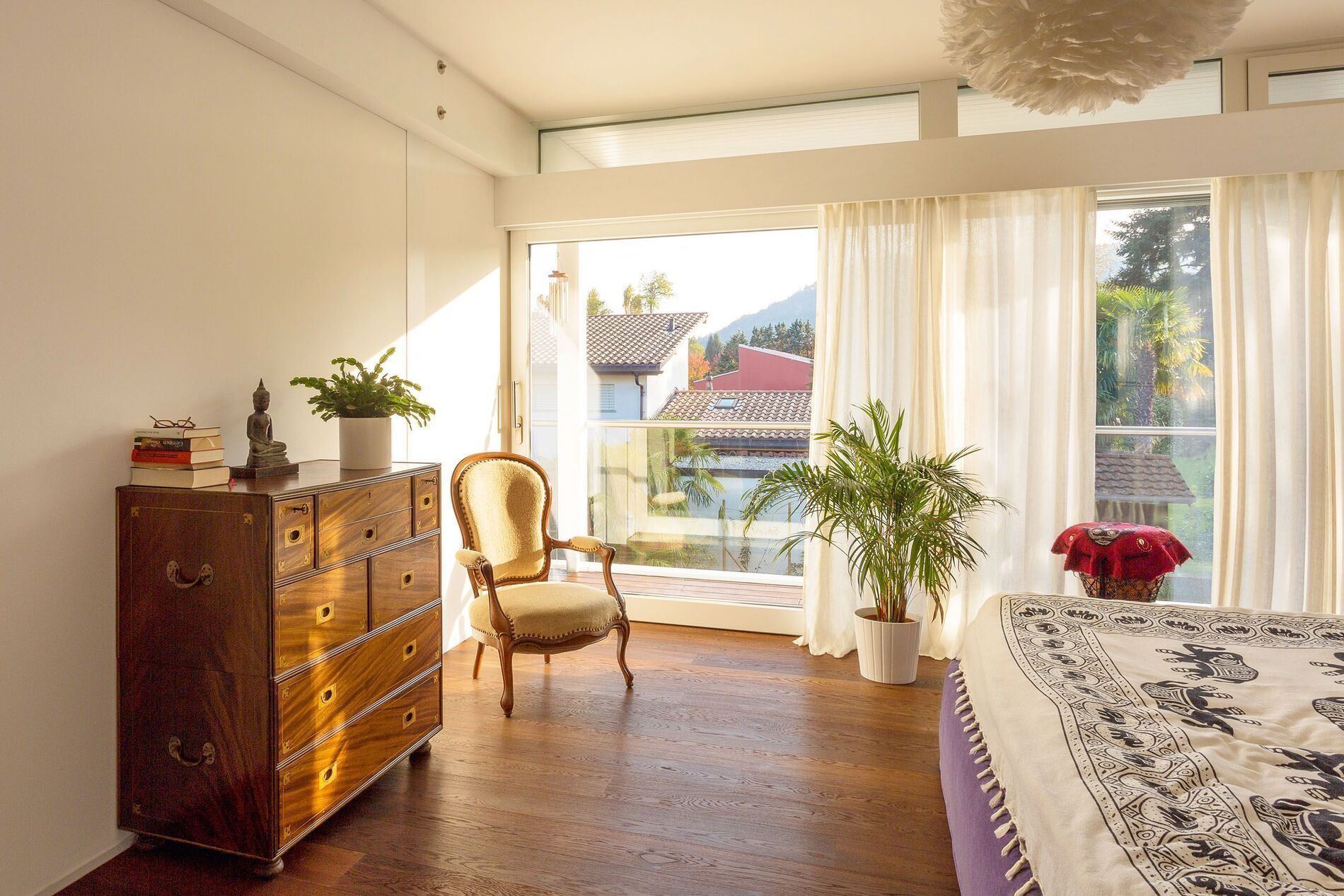 Elegantes Schlafzimmer mit modernem Flachdachdesign Helles Schlafzimmer mit Pflanzen, Holzkommode und Fensterblick