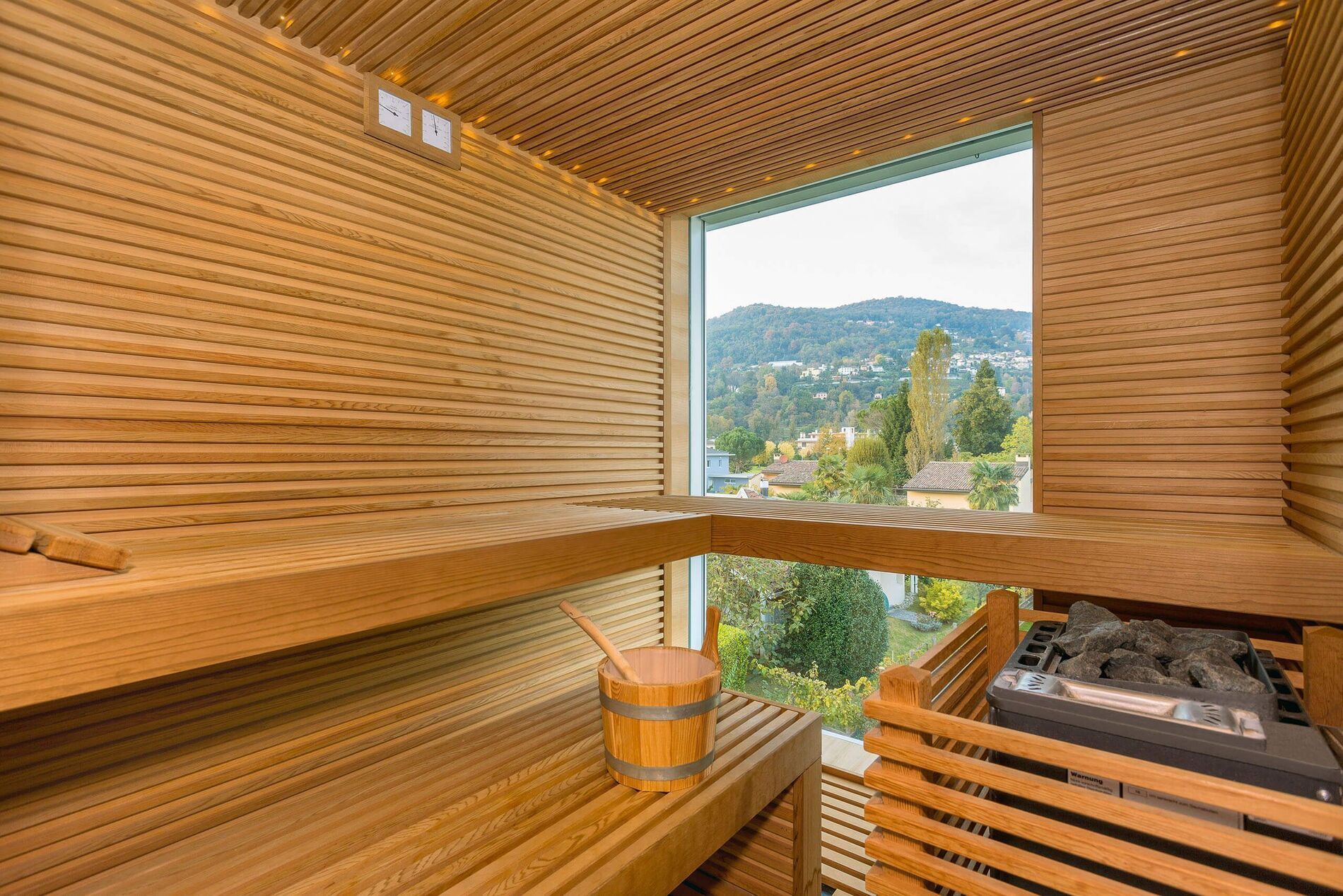 Moderne Sauna mit Holzverkleidung und Aussicht Innensicht einer privaten Sauna mit Holzregalen und Fenster