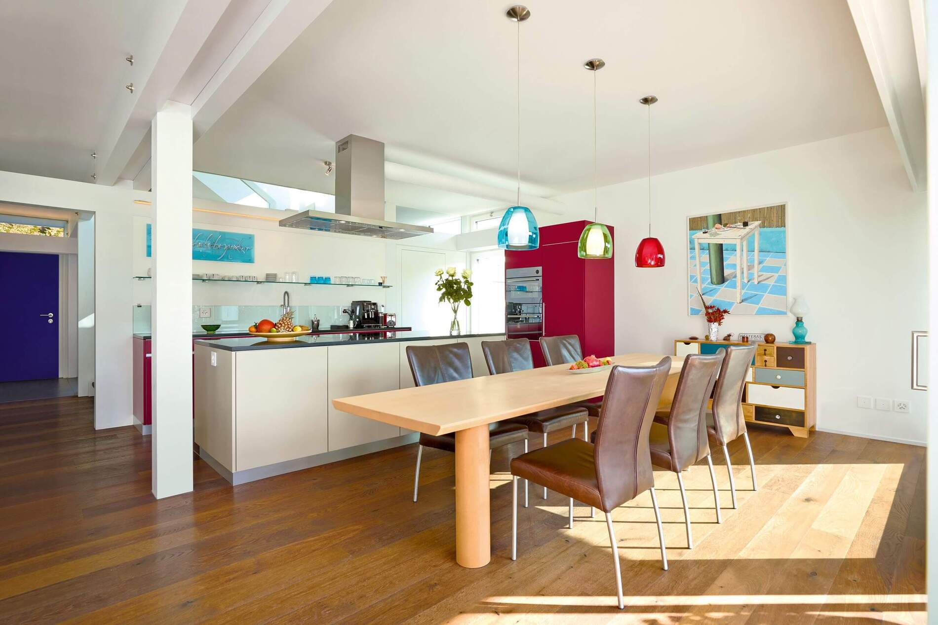 Moderne Küche mit Essbereich und eleganter Einrichtung Helle, moderne Küche mit Tisch und bunten Lampen, zeitloses Design