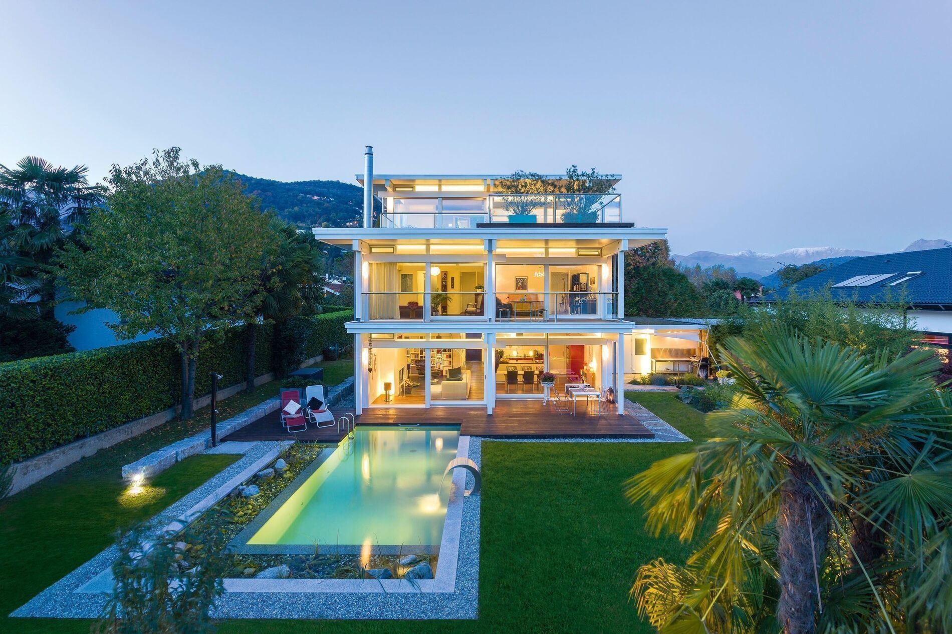 Modernes HUF Flachdachhaus mit eleganter Architektur HUF Flachdachhaus mit Pool und klaren Linien in der Abenddämmerung