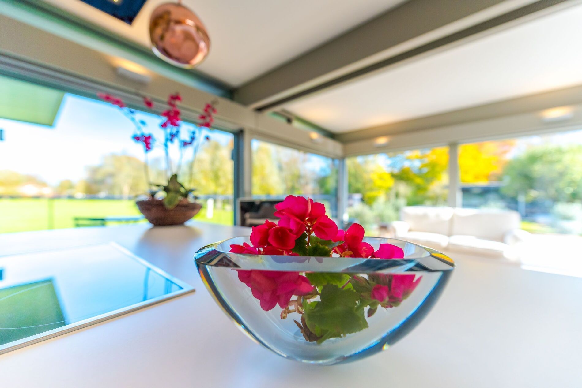 Eleganter HUF Anbau mit stilvollem Wohnraum Blumenarrangement im modernen HUF Anbau mit Glasflächen