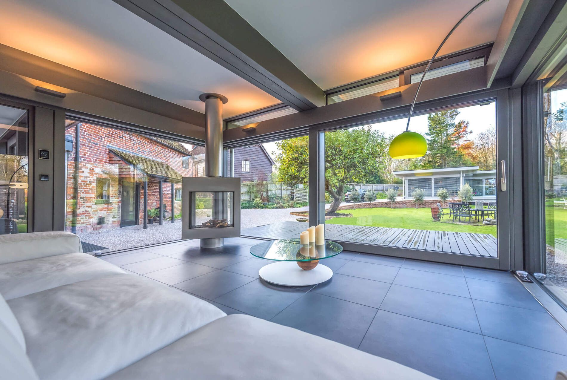 Stylischer HUF Anbau erweitert Wohnraum harmonisch Moderne Architektur mit Kamin und Blick ins Grüne