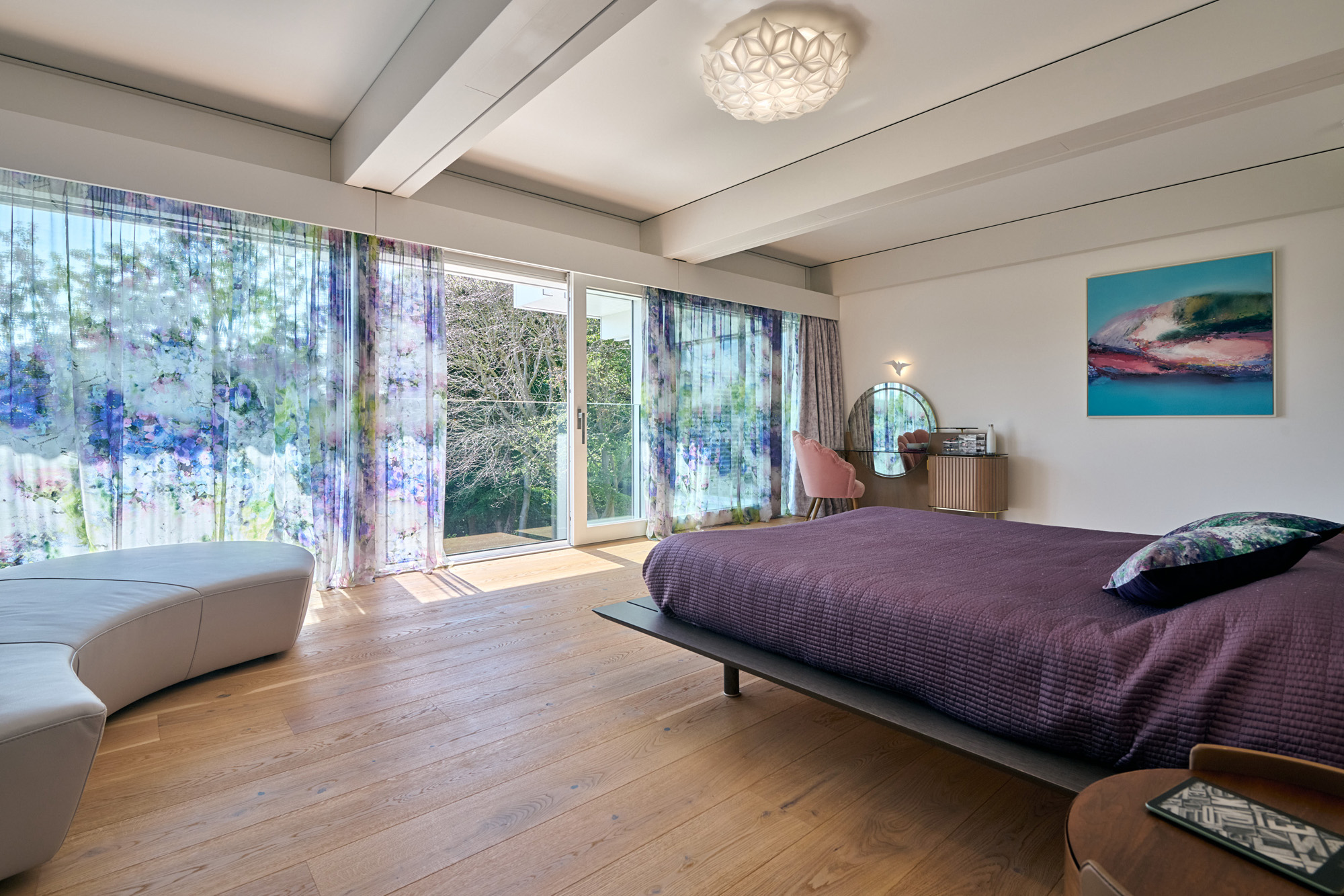 Elegantes Schlafzimmer mit Blick auf die Natur und großzügigen Fenstern