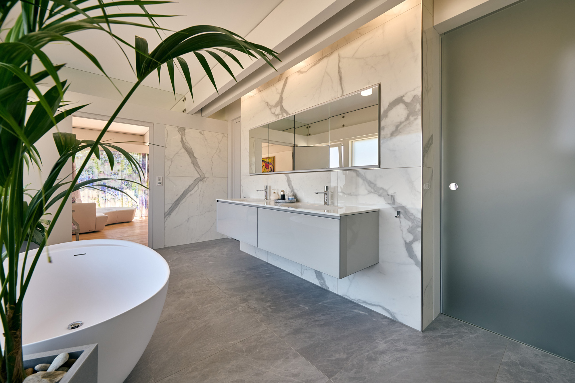 Modernes Badezimmer in weißer Villa mit Flachdach Helles Badezimmer mit Badewanne, Waschbecken und Spiegel