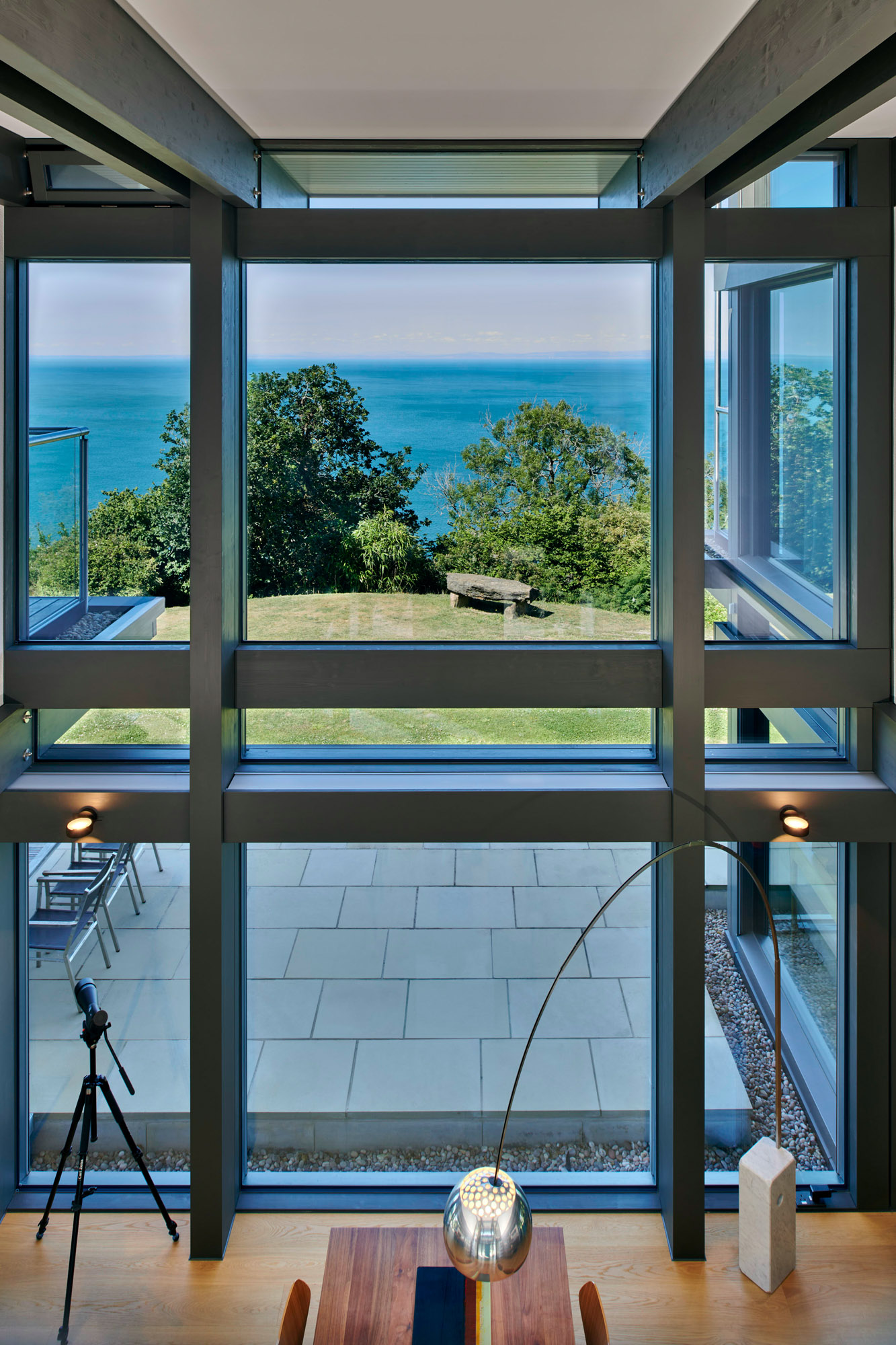 Blick durch große Fenster auf das Meer und die Umgebung des HUF Hauses