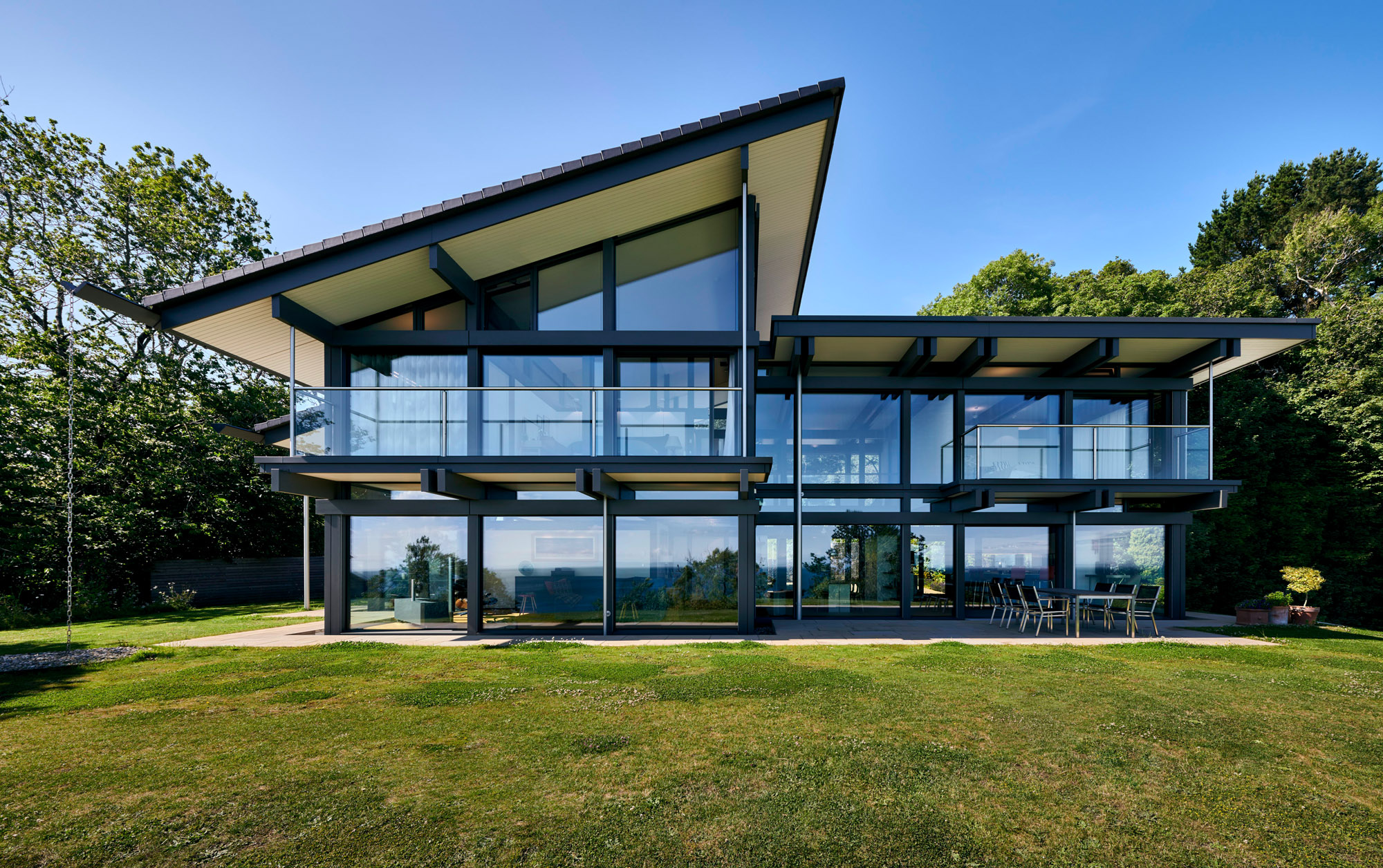 Stilvolles HUF Haus am Meer mit großen Glasfenstern und Garten