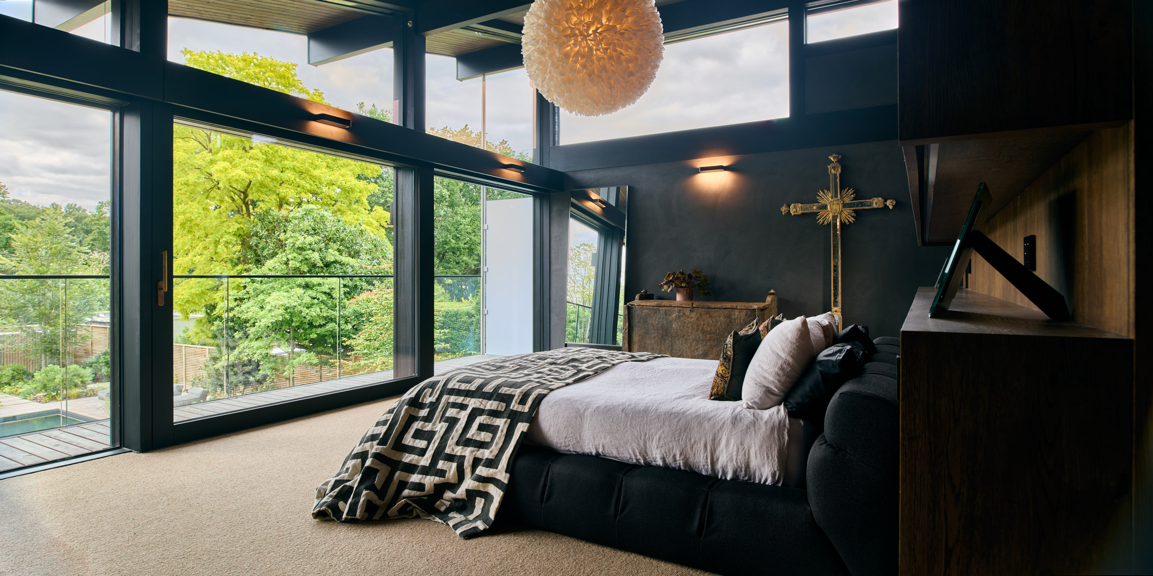 Luxuriöses Schlafzimmer mit Blick auf die Natur und stilvollen Akzenten